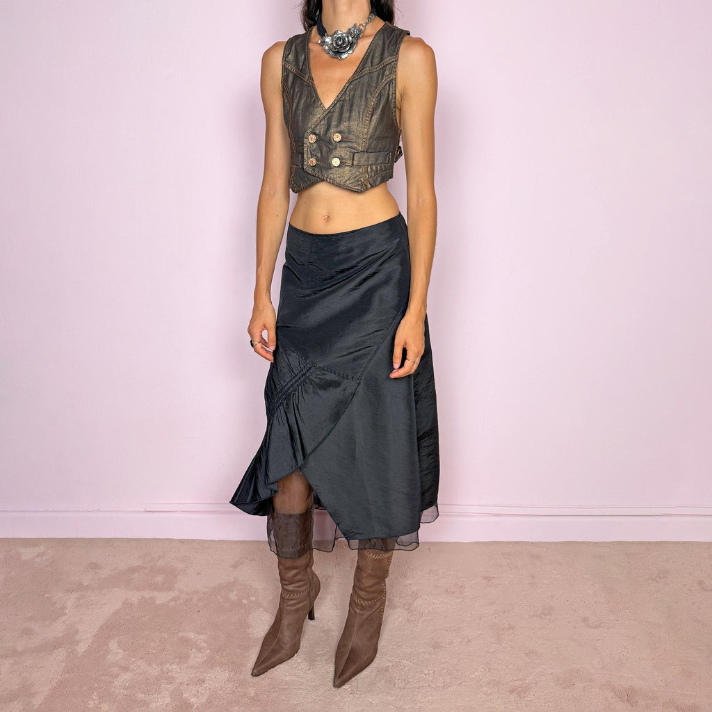 Vintage 2000s black midi skirt featuring an asymmetric deconstructed silhouette with diagonal paneling, gathered ruching, a sculptural draped insert, and a sheer black underlayer. Elegant dark avant-garde style, perfect for formal outfits. Non-stretch fabric with a back zip closure. Can be worn high-waisted for size M or slightly lower on the waist for sizes S and XS. Composition label is missing, so the exact fabric is unknown. From a French brand. Excellent vintage condition.