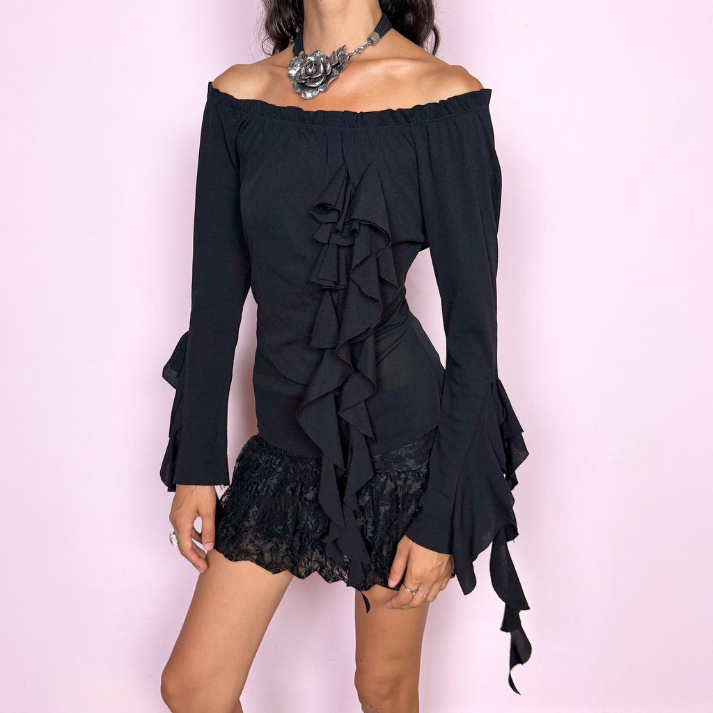 Vintage 2000s black top featuring an off-the-shoulder neckline, fitted silhouette, dramatic cascading front ruffles and flared ruffle cuffs, creating an asymmetric sculptural effect with an experimental avant-garde feel. Made in France by a French brand from stretchy 100% polyamide. Excellent vintage condition.