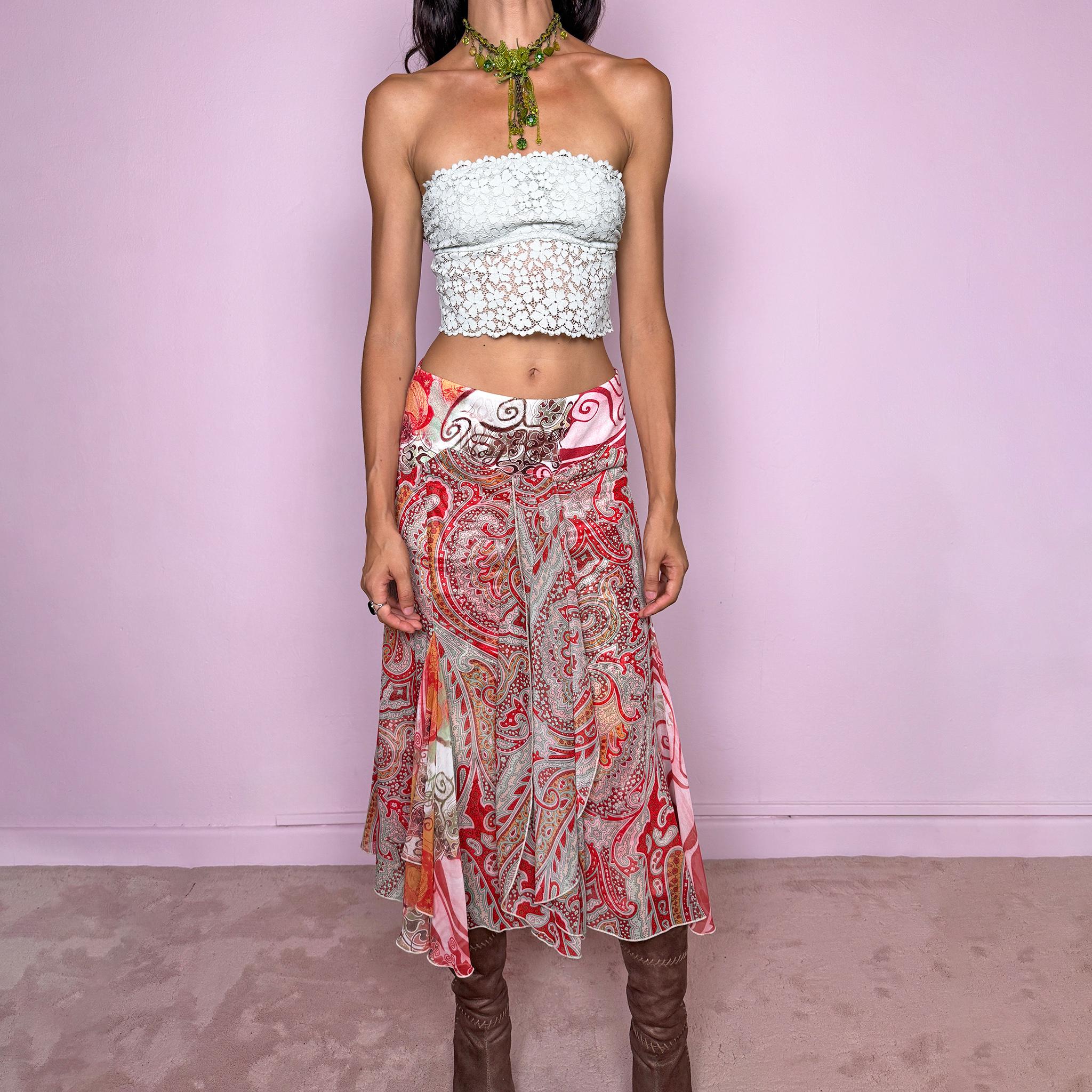 Vintage 2000s 100% silk midi skirt featuring a richly layered red, pink, and earthy-toned paisley and abstract print. The design combines a printed underlayer with a semi-sheer silk overlay, creating depth and movement as the two patterns interact. Cut with multiple godet inserts for a fluid flared silhouette and softly asymmetric hem, giving the skirt a romantic maximalist, art-to-wear feel. Non-stretch with a back zip closure. Can be worn mid-rise for size S or lower on the waist for size XS.