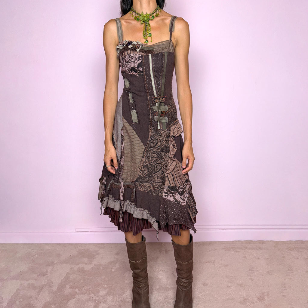 Vintage 2000s deconstructed midi dress with a distinctive rag-doll-inspired patchwork construction in brown, khaki green, mauve, and gray tones. Featuring mixed patterned panels, exposed raw-edge seams, contrast stitching, ribbon and buckle details, gathered ruffles, and an irregular layered hem for a highly textured avant-garde silhouette. Designed with adjustable shoulder straps, a shirred elastic back for flexibility, and a side zip closure.