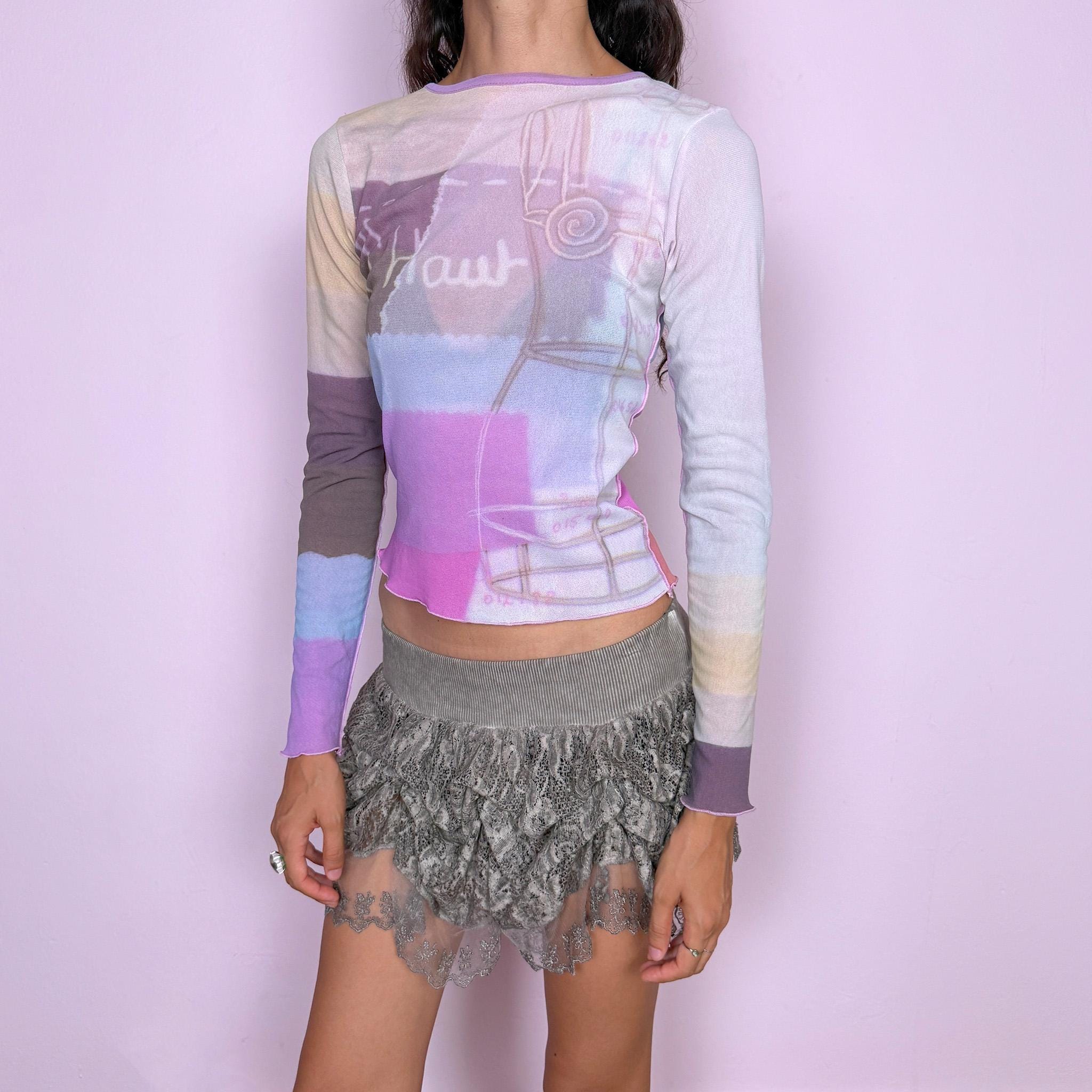 Vintage 2000s Cop Copine long-sleeve top featuring a soft pastel graphic print in lilac, cream, and pink tones. Designed with a fitted silhouette, round neckline, and contrasting color-blocked sleeves. Soft and stretchy with a lightweight, second-skin feel. A playful pastel Y2K piece by a French brand with a dreamy graphic-art aesthetic. The composition label is missing, so the exact fabric is unknown. Excellent vintage condition.