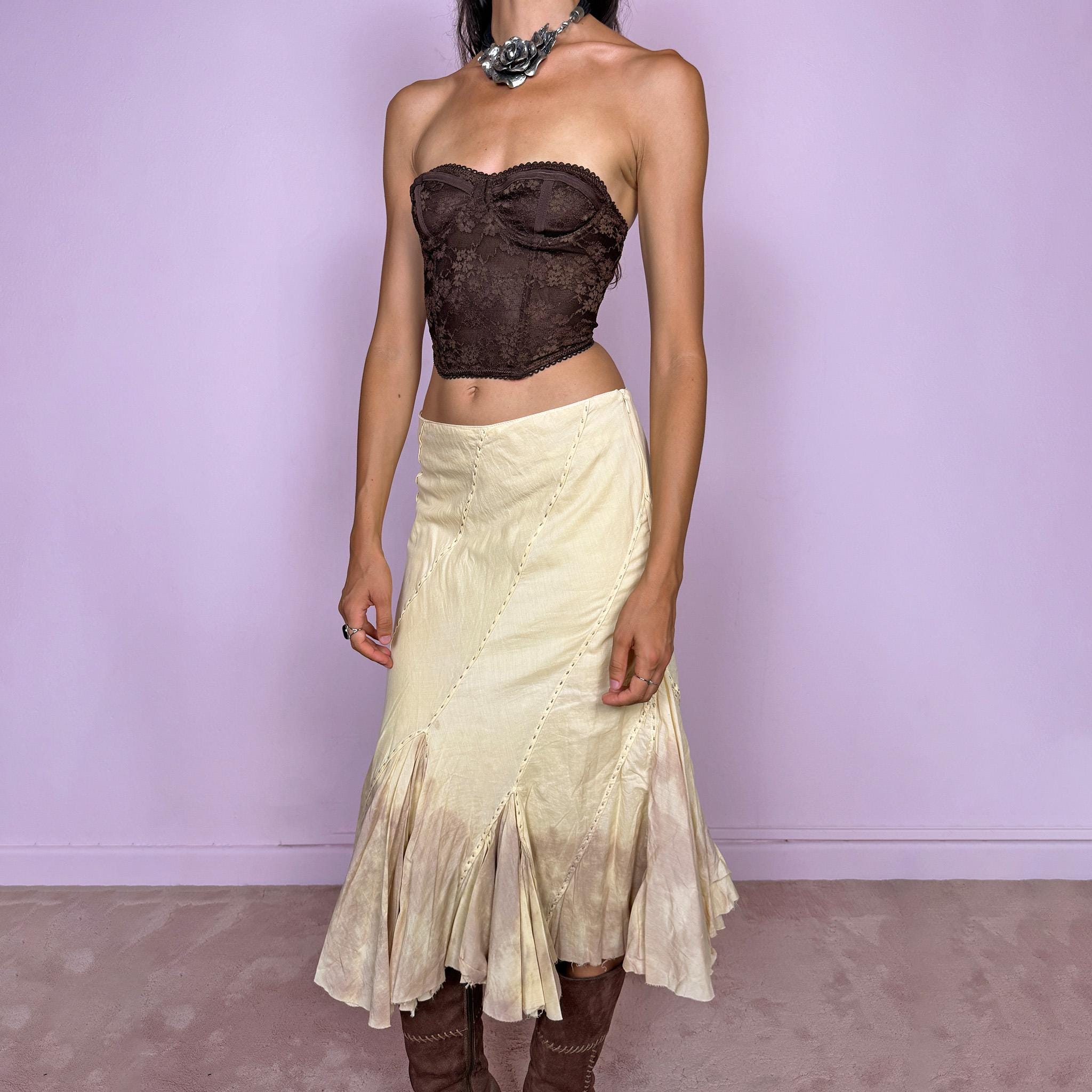 Vintage 2000s light yellow asymmetric midi skirt with a romantic, deconstructed silhouette, featuring curved diagonal paneling, visible contrast stitching, and flared godet inserts. Finished with a tie-dye effect concentrated around the lower panels and raw hem. Non-stretch fabric with a side zip closure. Can be worn mid-rise for size S or lower-rise for size XS. Ideal for bohemian, fairy-inspired, earthy, rustic, and organic summer styling.
