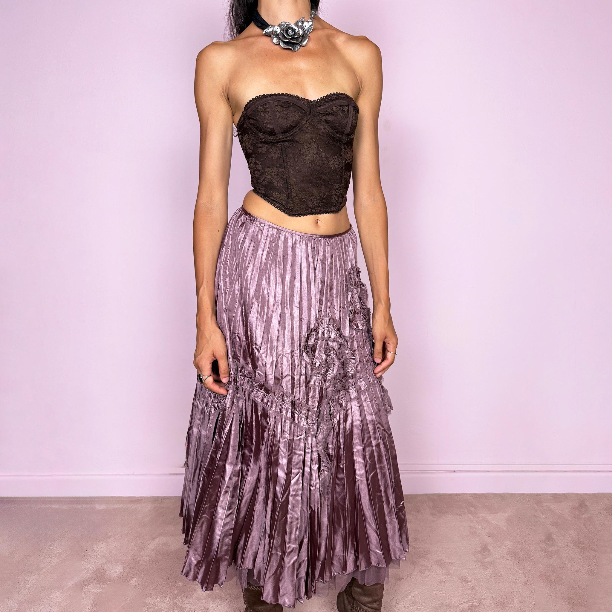 Vintage 2000s dusty mauve metallic midi skirt featuring intricate all-over pleating with a fluid iridescent sheen, sculptural floral appliqué details, and sheer tulle fabric peeking from underneath the hem. Ideal for parties or dreamy, romantic elevated outfits. Can be worn high-waisted for size S or lower on the waist for size XS. From a French brand. Crafted from 100% polyester with no stretch and finished with a side zip closure. Excellent vintage condition.