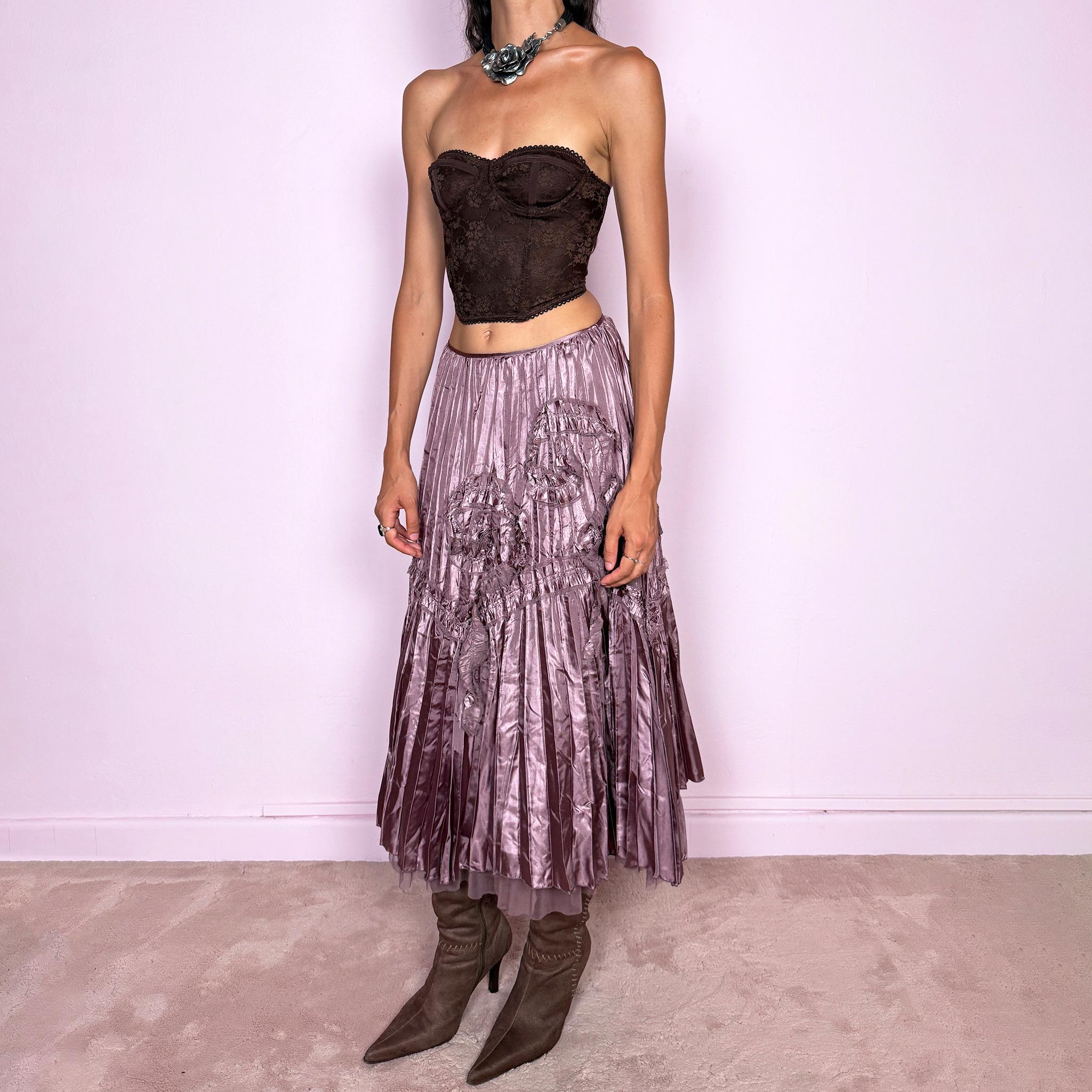 Vintage 2000s dusty mauve metallic midi skirt featuring intricate all-over pleating with a fluid iridescent sheen, sculptural floral appliqué details, and sheer tulle fabric peeking from underneath the hem. Ideal for parties or dreamy, romantic elevated outfits. Can be worn high-waisted for size S or lower on the waist for size XS. From a French brand. Crafted from 100% polyester with no stretch and finished with a side zip closure. Excellent vintage condition.