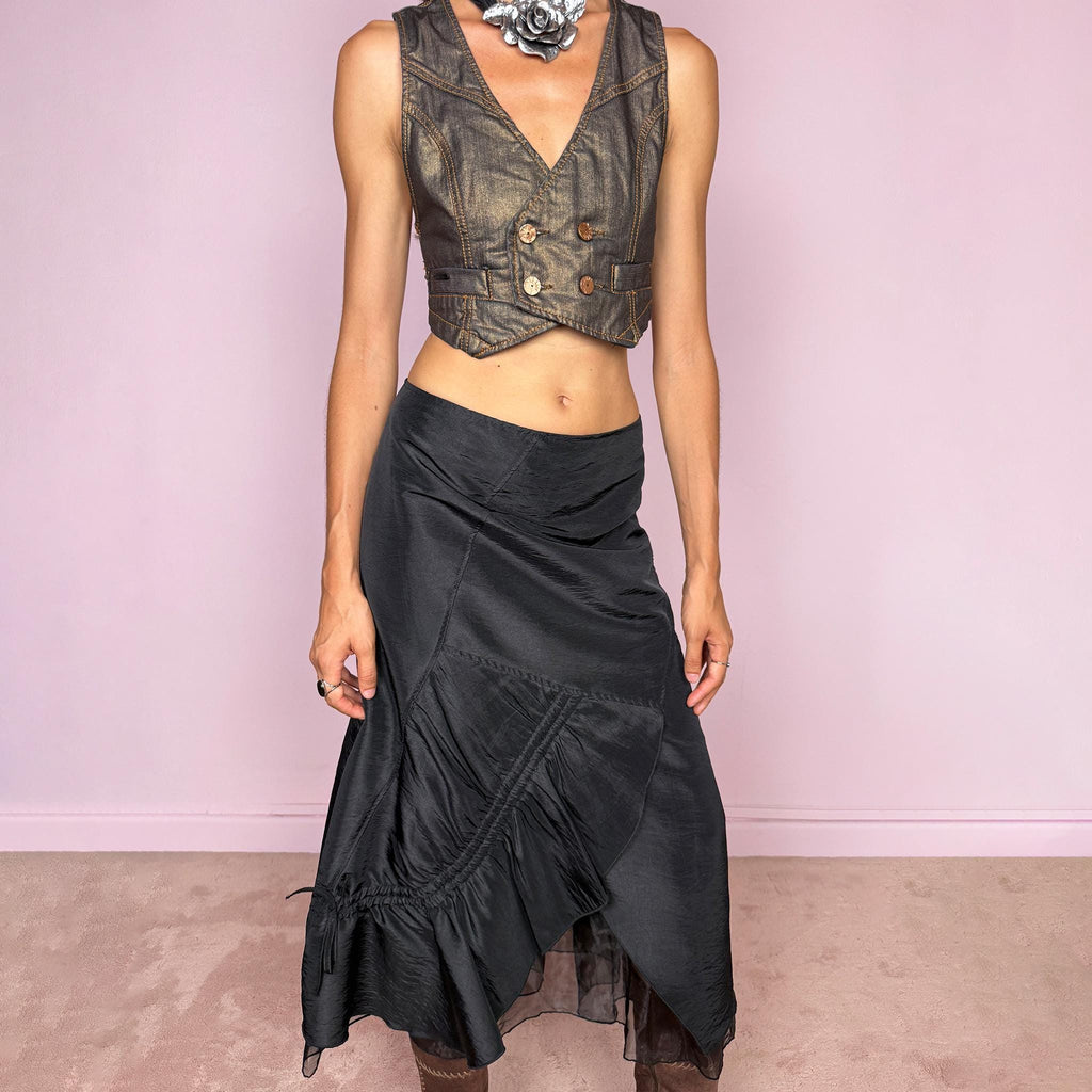 Vintage 2000s black midi skirt featuring an asymmetric deconstructed silhouette with diagonal paneling, gathered ruching, a sculptural draped insert, and a sheer black underlayer. Elegant dark avant-garde style, perfect for formal outfits. Non-stretch fabric with a back zip closure. Can be worn high-waisted for size M or slightly lower on the waist for sizes S and XS. Composition label is missing, so the exact fabric is unknown. From a French brand. Excellent vintage condition.