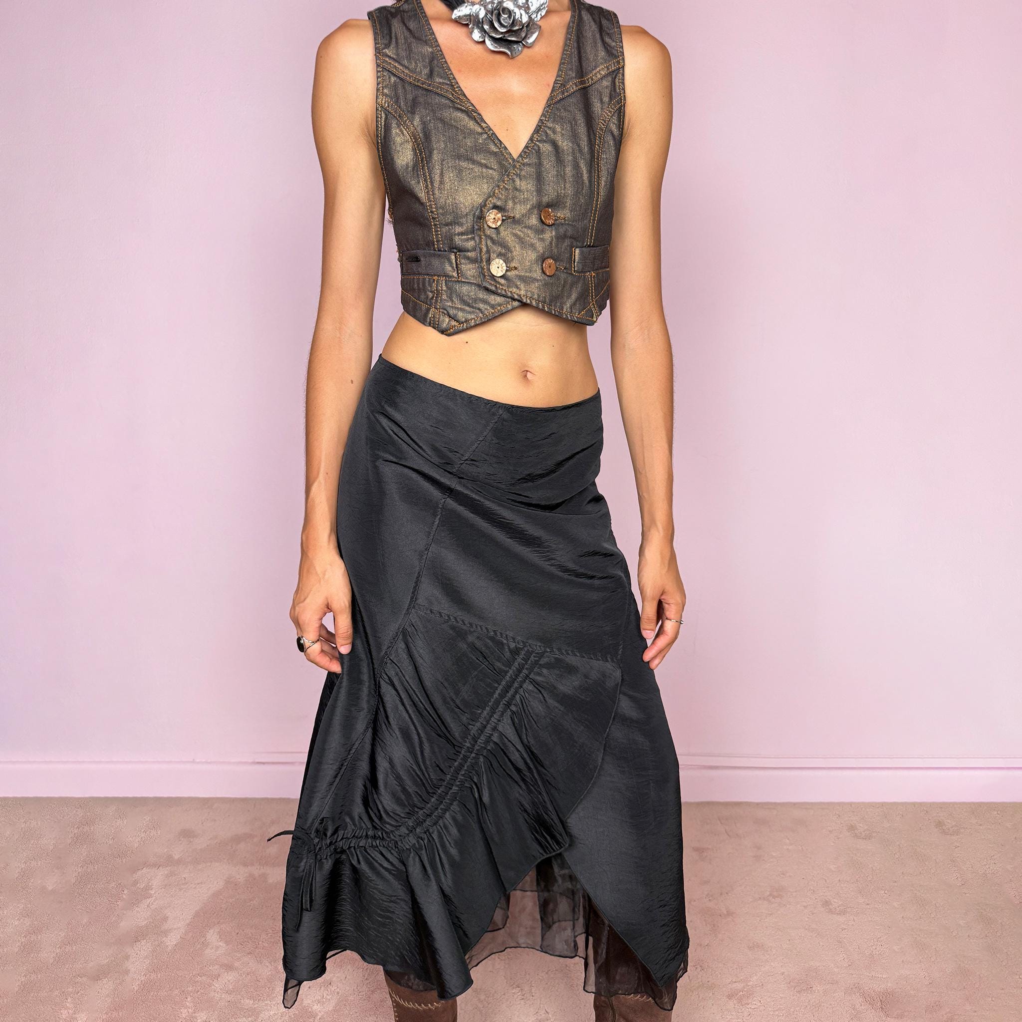Vintage 2000s black midi skirt featuring an asymmetric deconstructed silhouette with diagonal paneling, gathered ruching, a sculptural draped insert, and a sheer black underlayer. Elegant dark avant-garde style, perfect for formal outfits. Non-stretch fabric with a back zip closure. Can be worn high-waisted for size M or slightly lower on the waist for sizes S and XS. Composition label is missing, so the exact fabric is unknown. From a French brand. Excellent vintage condition.