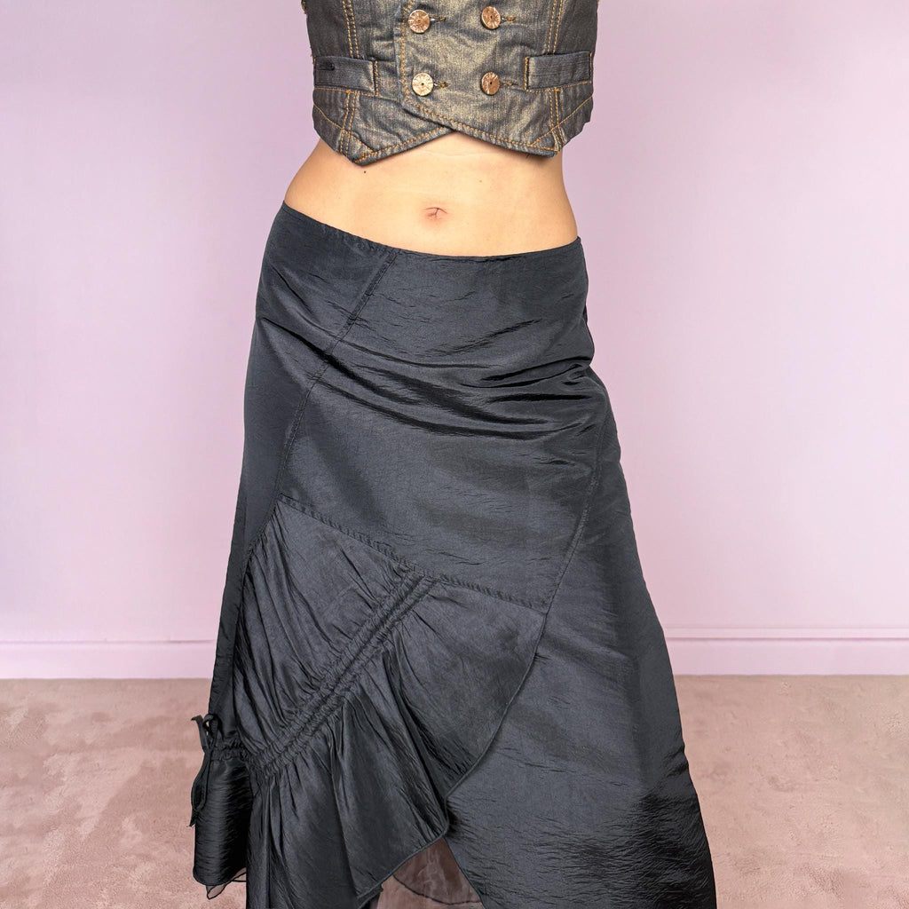 Vintage 2000s black midi skirt featuring an asymmetric deconstructed silhouette with diagonal paneling, gathered ruching, a sculptural draped insert, and a sheer black underlayer. Elegant dark avant-garde style, perfect for formal outfits. Non-stretch fabric with a back zip closure. Can be worn high-waisted for size M or slightly lower on the waist for sizes S and XS. Composition label is missing, so the exact fabric is unknown. From a French brand. Excellent vintage condition.