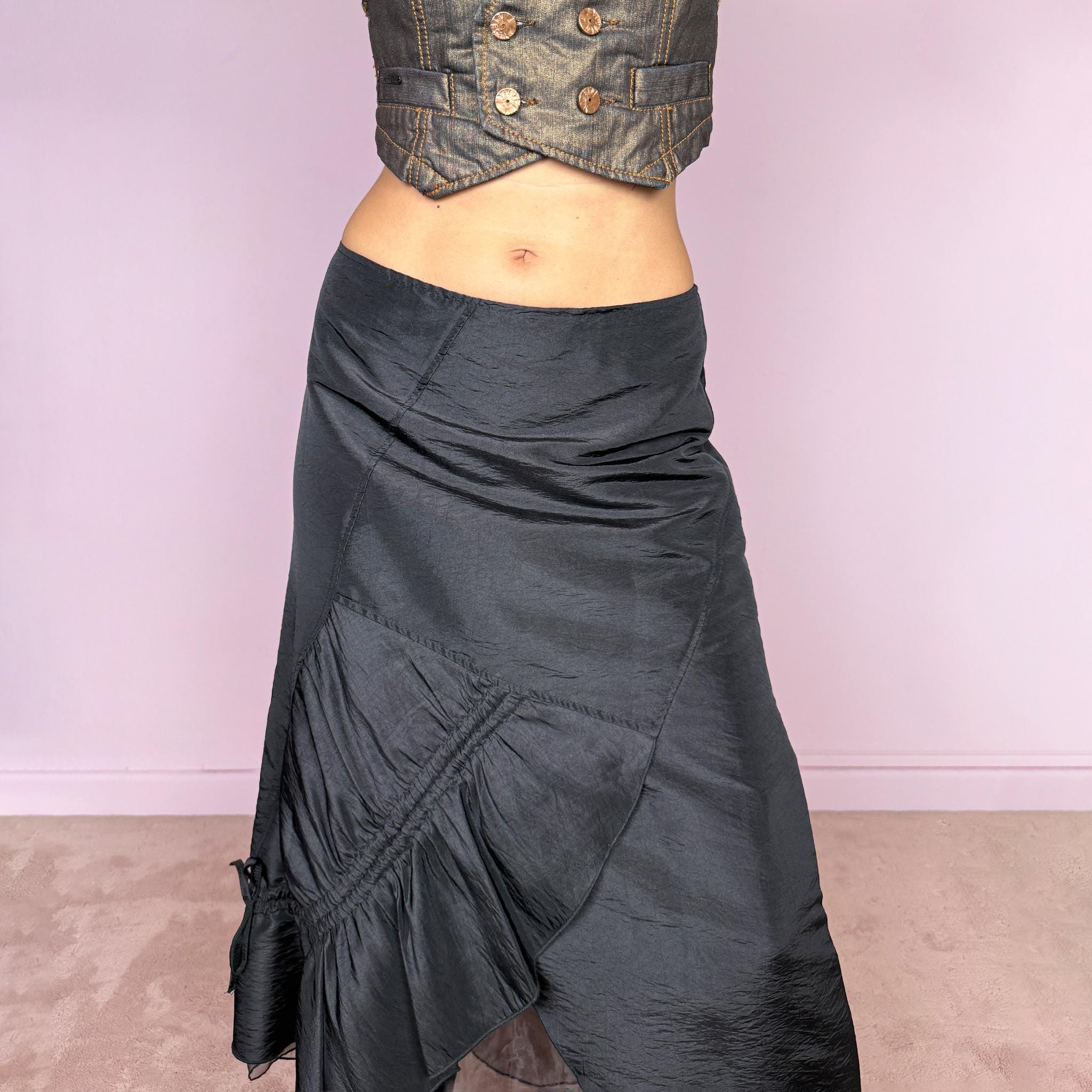 Vintage 2000s black midi skirt featuring an asymmetric deconstructed silhouette with diagonal paneling, gathered ruching, a sculptural draped insert, and a sheer black underlayer. Elegant dark avant-garde style, perfect for formal outfits. Non-stretch fabric with a back zip closure. Can be worn high-waisted for size M or slightly lower on the waist for sizes S and XS. Composition label is missing, so the exact fabric is unknown. From a French brand. Excellent vintage condition.