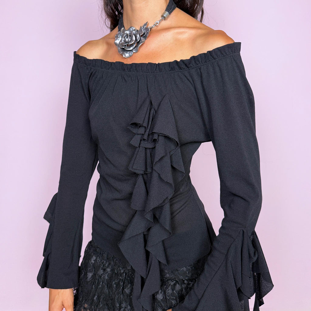 Vintage 2000s black top featuring an off-the-shoulder neckline, fitted silhouette, dramatic cascading front ruffles and flared ruffle cuffs, creating an asymmetric sculptural effect with an experimental avant-garde feel. Made in France by a French brand from stretchy 100% polyamide. Excellent vintage condition.