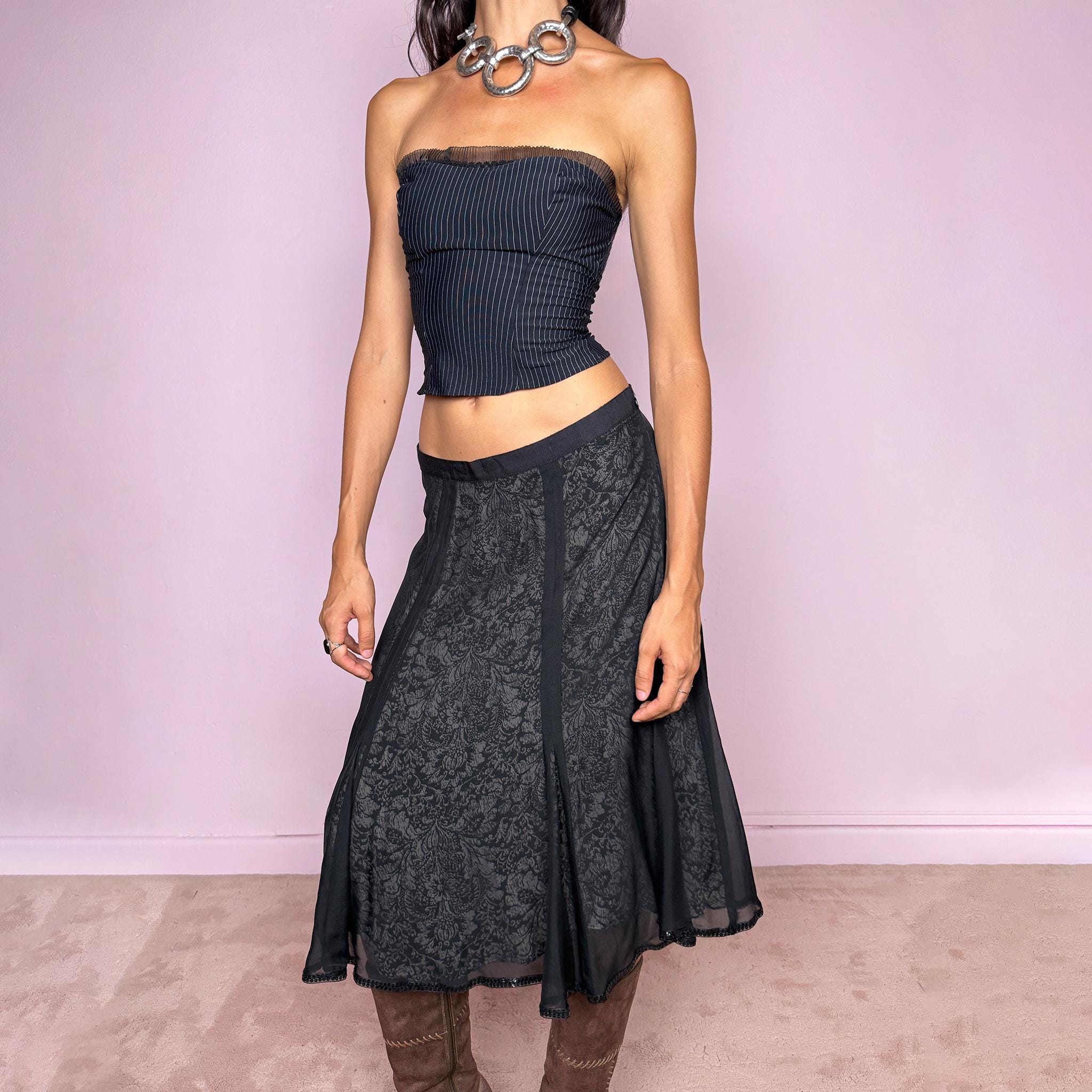 Vintage 2000s black silk A-line flared midi skirt crafted from 100% silk, with contrasting beige and black lining that subtly reveals an intricate dark floral paisley pattern through the outer fabric, a semi-sheer black overlay, and delicate black sequin trim along the edge. Elegant with a romantic eveningwear feel. Non-stretch with a side zip closure. Can be worn mid-rise for size M or lower-rise for size S. From a German brand. Excellent vintage condition.