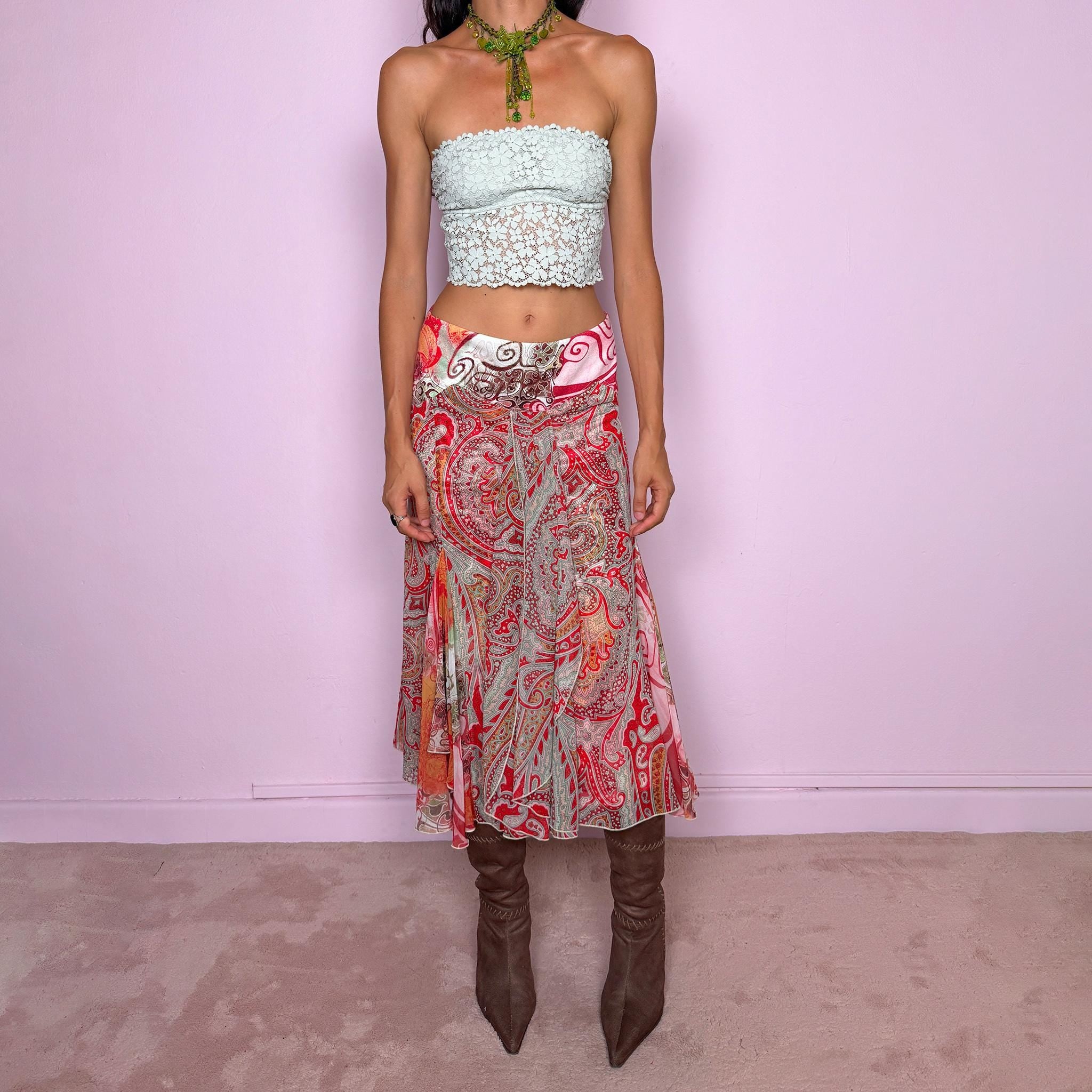 Vintage 2000s 100% silk midi skirt featuring a richly layered red, pink, and earthy-toned paisley and abstract print. The design combines a printed underlayer with a semi-sheer silk overlay, creating depth and movement as the two patterns interact. Cut with multiple godet inserts for a fluid flared silhouette and softly asymmetric hem, giving the skirt a romantic maximalist, art-to-wear feel. Non-stretch with a back zip closure. Can be worn mid-rise for size S or lower on the waist for size XS.