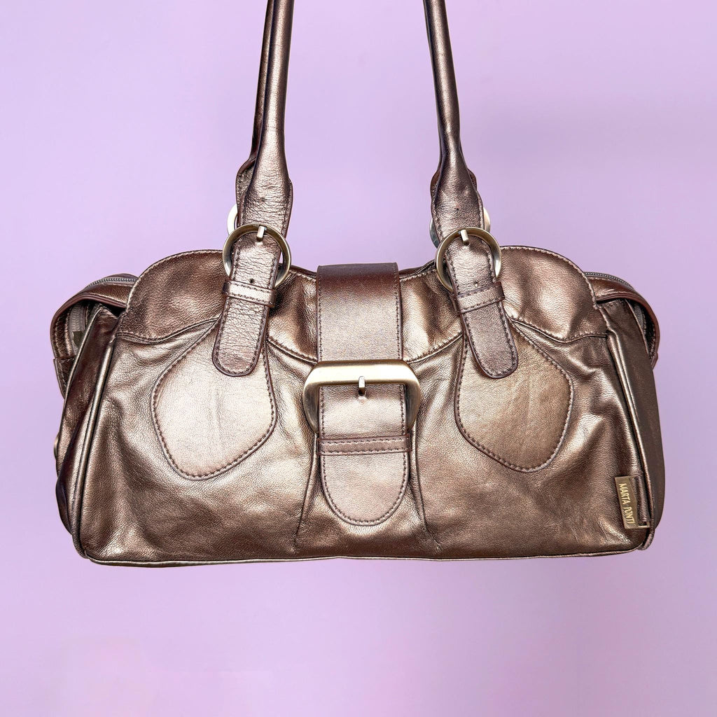 Vintage 2000s metallic bronze-gold leather handbag crafted from genuine leather. Features a structured rectangular silhouette with double shoulder straps and a statement buckle accent. Finished with a top zip closure and snap-button fastening. The warm metallic finish shifts between antique gold and bronze. From a Portuguese leather goods brand. Excellent vintage condition.