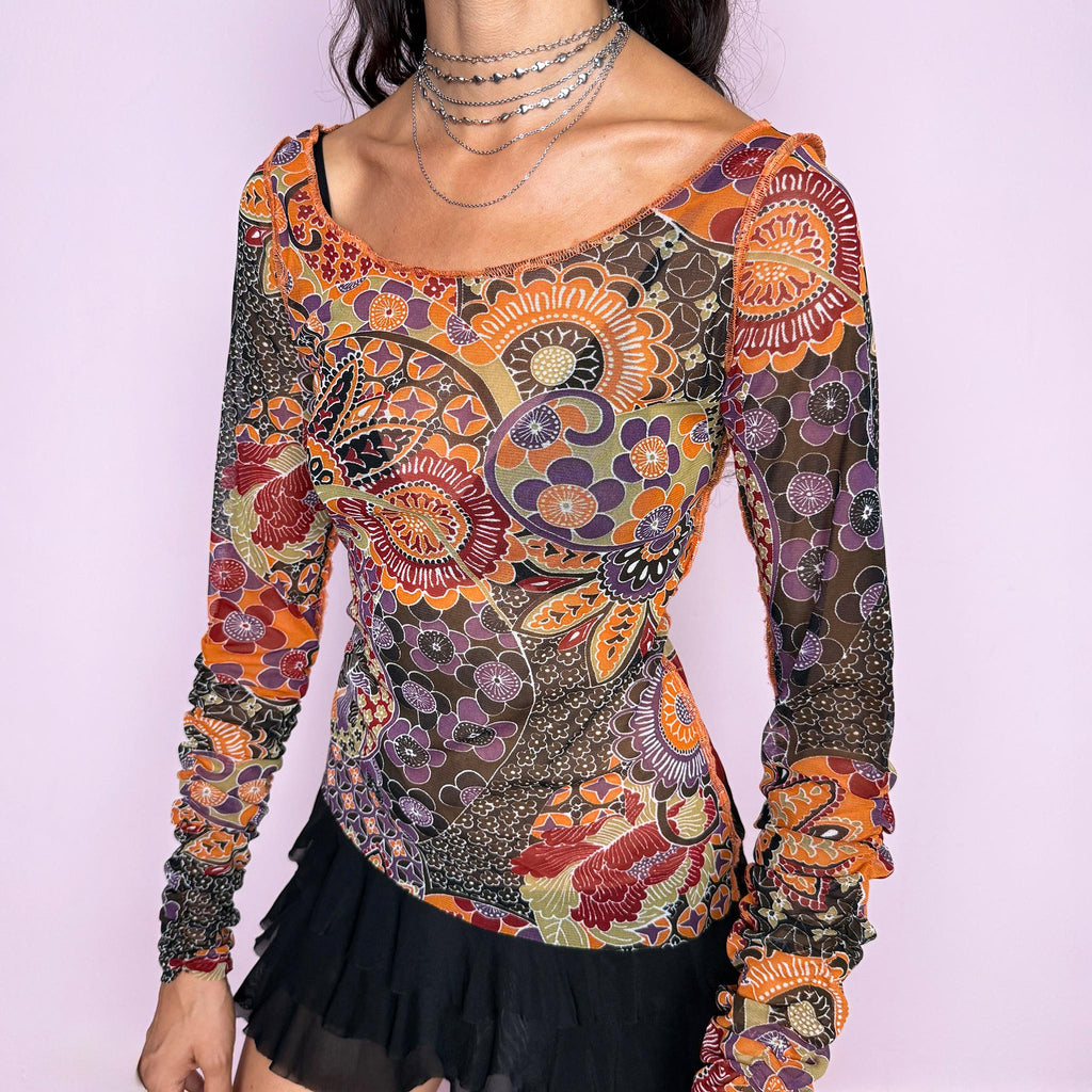 Vintage 2000s semi-sheer printed top featuring a fitted, stretchy silhouette with an intricate floral and paisley-inspired print in warm orange, burgundy, olive, brown, and muted purple tones. Designed with a wide scoop neckline and dramatic ruched long sleeves for a playful, maximalist art-to-wear aesthetic. Made in France by a French brand from 100% polyester. Excellent vintage condition.