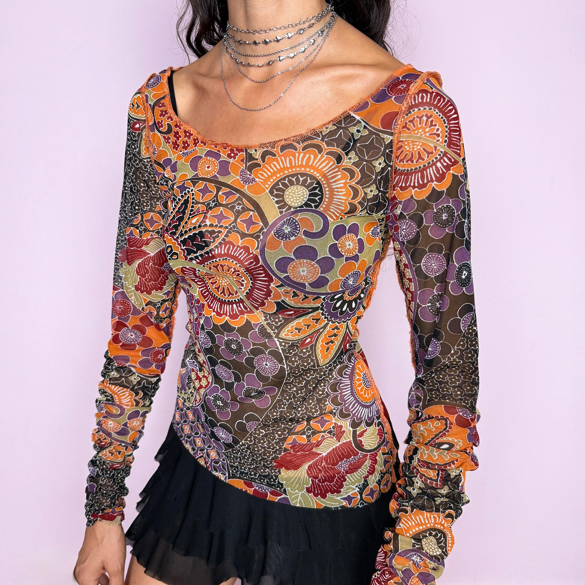 Vintage 2000s semi-sheer printed top featuring a fitted, stretchy silhouette with an intricate floral and paisley-inspired print in warm orange, burgundy, olive, brown, and muted purple tones. Designed with a wide scoop neckline and dramatic ruched long sleeves for a playful, maximalist art-to-wear aesthetic. Made in France by a French brand from 100% polyester. Excellent vintage condition.