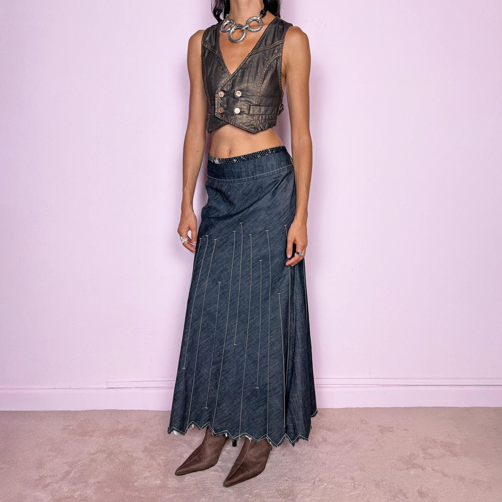 Vintage 2000s blue denim maxi skirt by Marithé + François Girbaud, from the Le Jean de Marithé + François Girbaud line. Made in Italy from a structured 77% cotton and 23% polyester blend. Featuring a side zip closure, contrast stitching, and a flared lower section with elongated vertical stitch detailing and a sculptural, pointed, frayed raw hem. Non-stretch. Can be worn mid-rise for size M. The architectural construction gives it an avant-garde designer aesthetic. Excellent vintage condition.