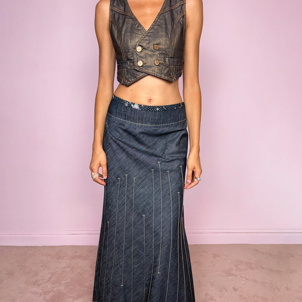 Vintage 2000s blue denim maxi skirt by Marithé + François Girbaud, from the Le Jean de Marithé + François Girbaud line. Made in Italy from a structured 77% cotton and 23% polyester blend. Featuring a side zip closure, contrast stitching, and a flared lower section with elongated vertical stitch detailing and a sculptural, pointed, frayed raw hem. Non-stretch. Can be worn mid-rise for size M. The architectural construction gives it an avant-garde designer aesthetic. Excellent vintage condition.