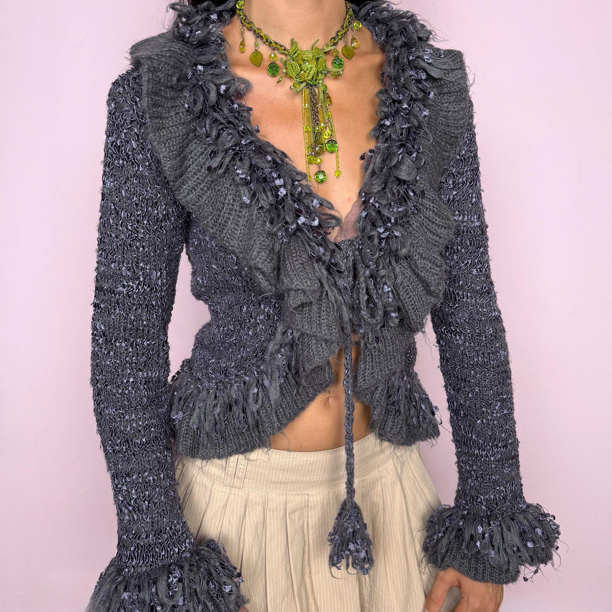 Vintage 2000s romantic gray tie-front cardigan crafted from a fuzzy 70% mohair, 20% acrylic, and 10% elastane blend. Featuring an adjustable tie fastening, dramatic textured fringe ruffle detailing along the neckline and hem, and long sleeves finished with ruffle cuffs. The brand label is missing. Excellent vintage condition.
