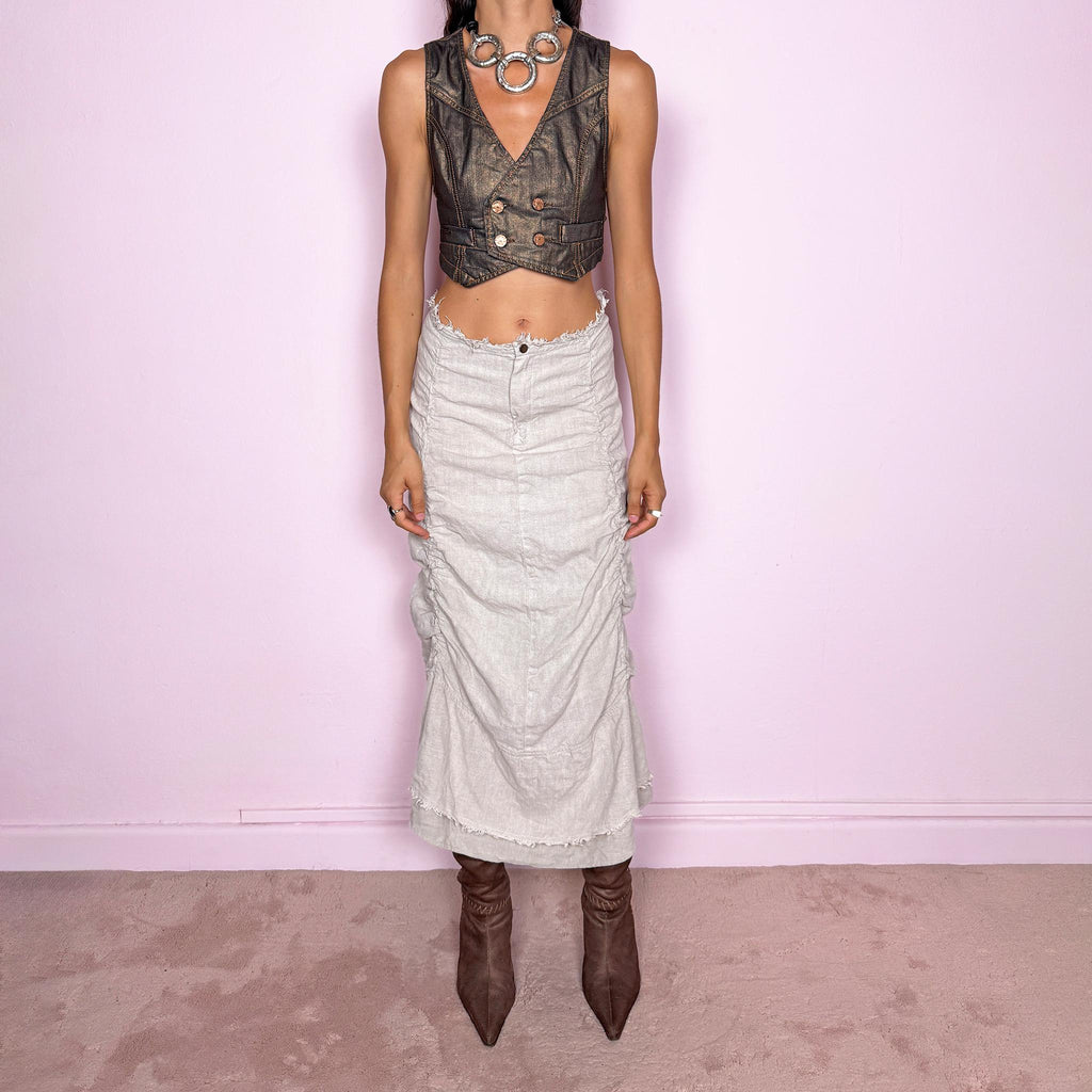 Vintage 2000s grayish off-white/light greige maxi skirt crafted from 100% linen, featuring sculptural ruched side detailing, softly gathered seams, and a flared layered hem with raw, frayed edges. The natural linen texture and muted earthy tone give it an avant-garde, rustic aesthetic. Non-stretch with a front zip closure. Can be worn high-waisted for size S or lower on the waist for size XS. Excellent vintage condition.