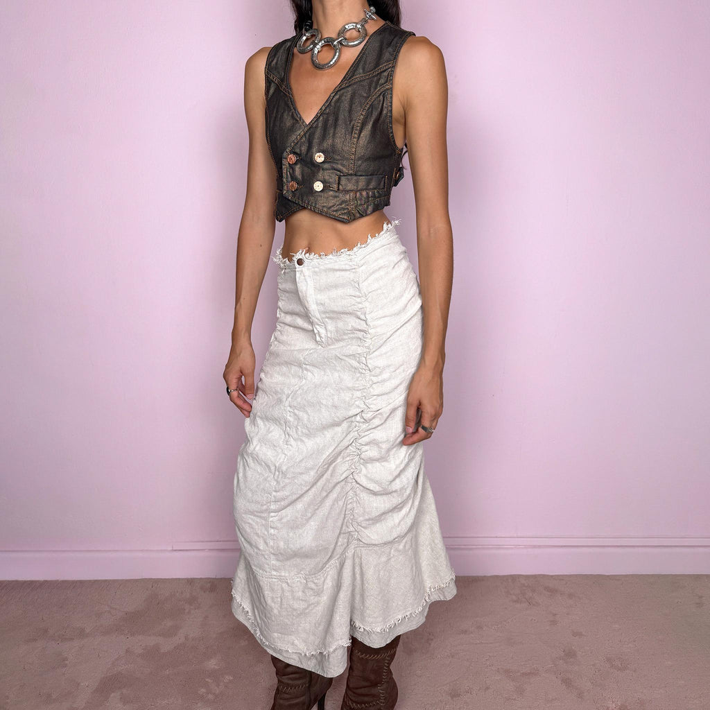 Vintage 2000s grayish off-white/light greige maxi skirt crafted from 100% linen, featuring sculptural ruched side detailing, softly gathered seams, and a flared layered hem with raw, frayed edges. The natural linen texture and muted earthy tone give it an avant-garde, rustic aesthetic. Non-stretch with a front zip closure. Can be worn high-waisted for size S or lower on the waist for size XS. Excellent vintage condition.