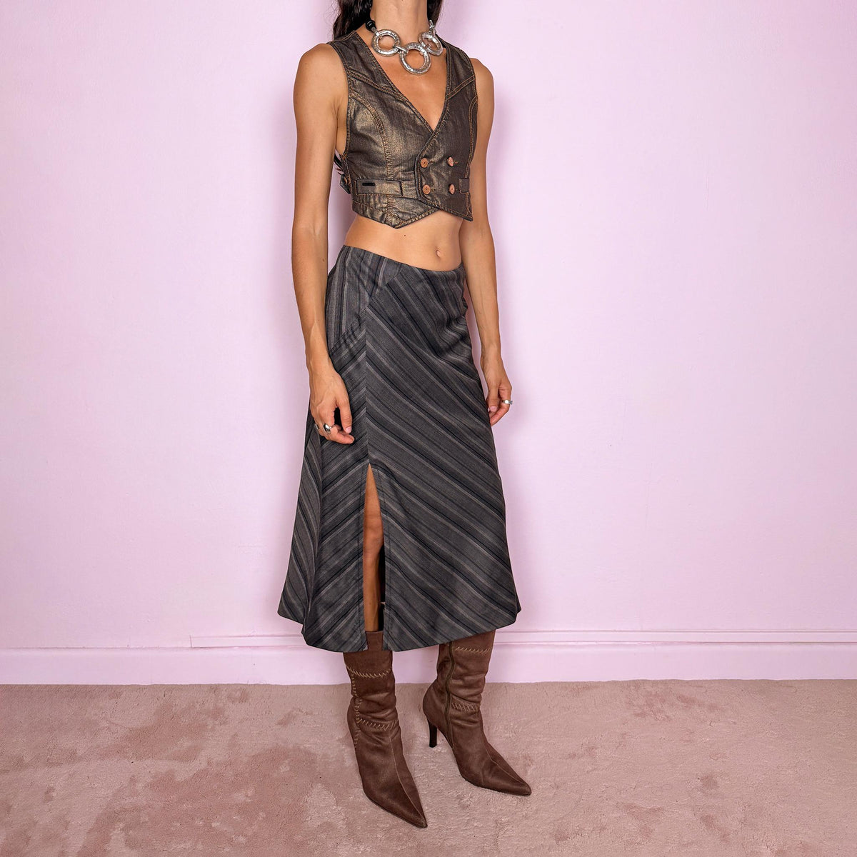 Vintage 2000s brownish-gray striped midi skirt by Kenzo Jungle, featuring diagonal stripe placement, a side slit, and a side zip closure. The muted brown-gray palette and refined tailoring give it a sophisticated, minimalist designer aesthetic. Can be worn mid-rise for size M. Crafted from a non-stretch blend of 58% viscose, 30% wool, 9% mohair, and 3% elastane, with a 100% polyester lining. Excellent vintage condition.