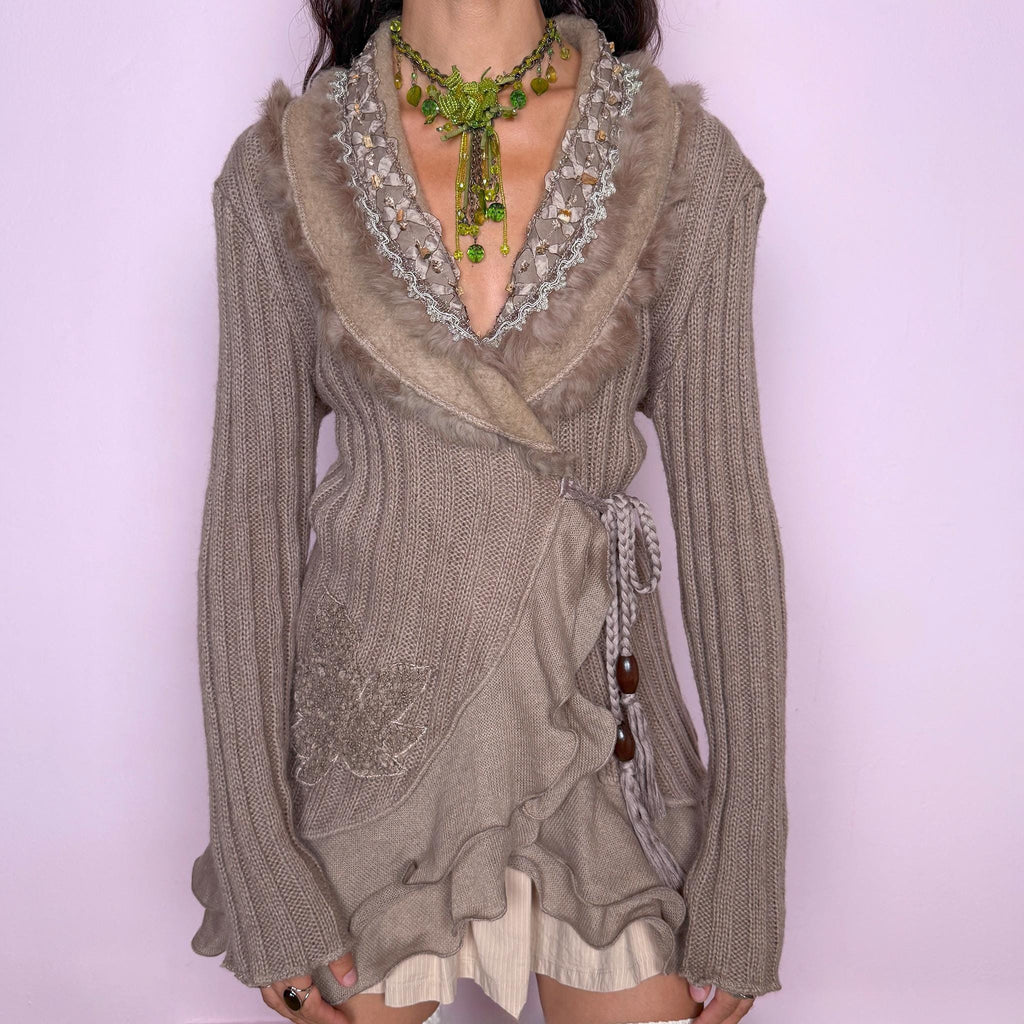 Vintage 2000s taupe-brown wrap cardigan crafted from a soft blend of 30% mohair, 20% wool, and 50% acrylic. Featuring a ribbed knit body, wrap-front silhouette with a braided tie fastening and wooden bead details, layered ruffle trim along the lower front, textured embroidery, and a plush faux-fur-trimmed shawl collar with beaded detailing. Excellent vintage condition.