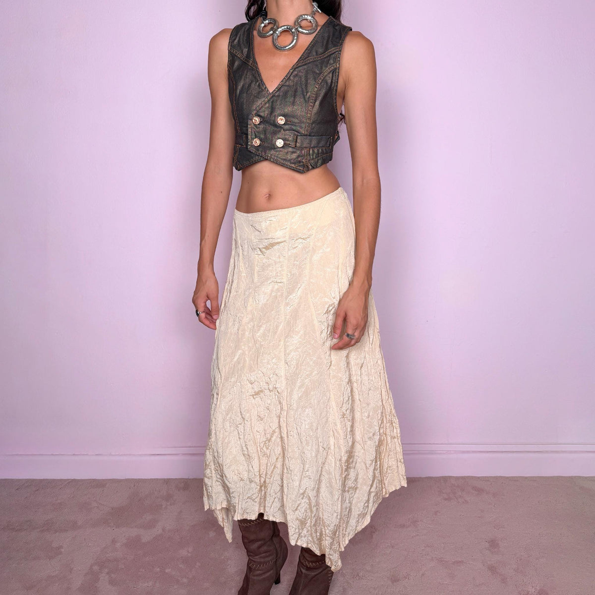 Vintage 2000s light cream-gold asymmetric midi skirt featuring a flared silhouette with an irregular handkerchief-style hem and a subtly crinkled, textured finish. Crafted from a structured, non-stretch blend of 53% polyamide, 32% cotton and 15% metallic fiber, with a 65% acetate and 35% viscose lining. Finished with a side zip closure. Can be worn mid-rise for size S or lower on the waist for size XS. From a German brand. Excellent vintage condition.