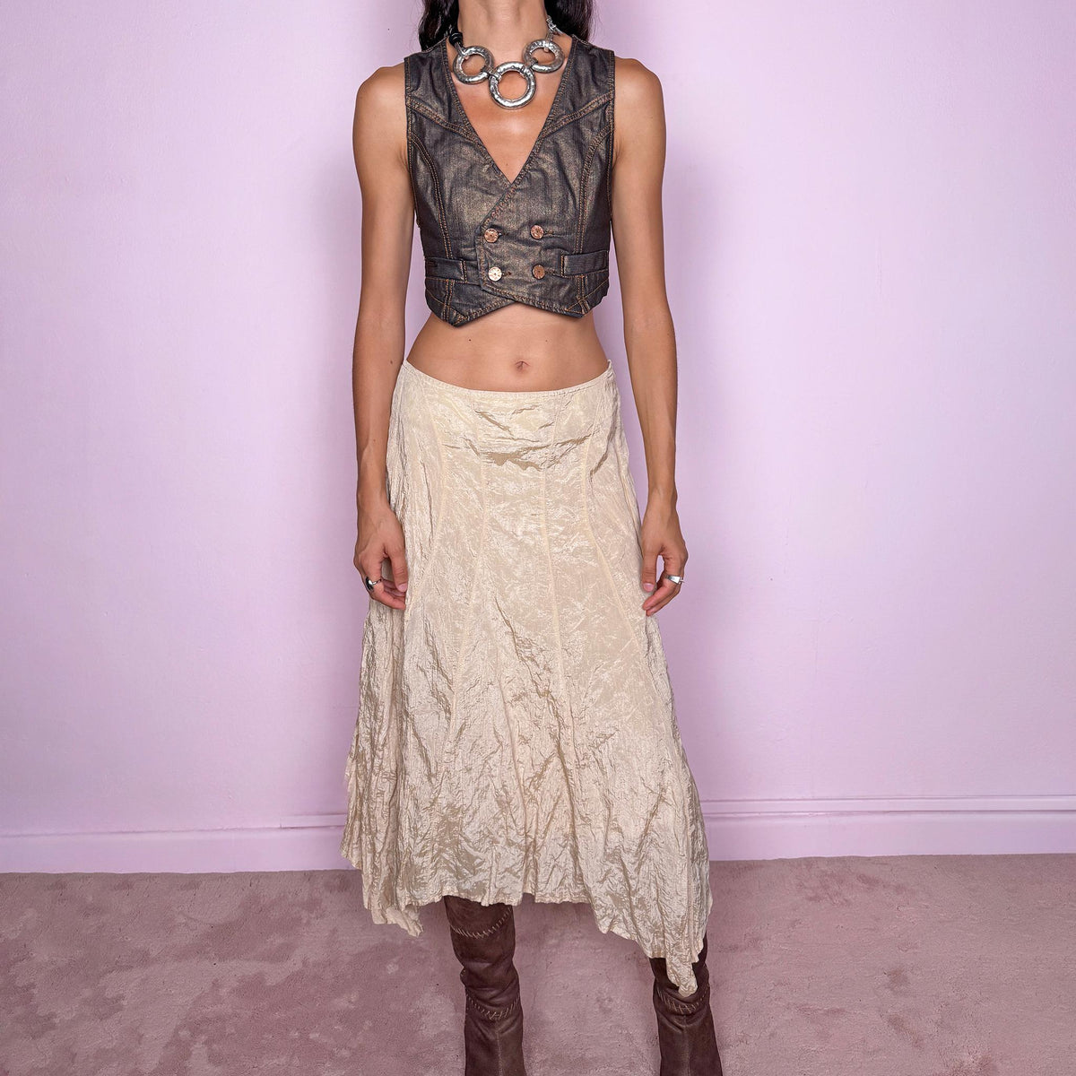 Vintage 2000s light cream-gold asymmetric midi skirt featuring a flared silhouette with an irregular handkerchief-style hem and a subtly crinkled, textured finish. Crafted from a structured, non-stretch blend of 53% polyamide, 32% cotton and 15% metallic fiber, with a 65% acetate and 35% viscose lining. Finished with a side zip closure. Can be worn mid-rise for size S or lower on the waist for size XS. From a German brand. Excellent vintage condition.