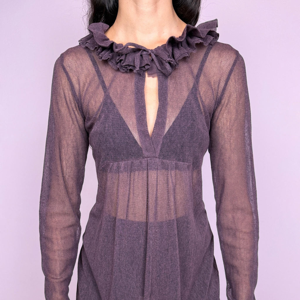 Vintage 2000s dark purple sheer dress by French label Cop Copine. Featuring a semi-sheer long-sleeve silhouette with a front tie detail at the neckline, layered ruffle trim and an asymmetric draped hem. Romantic avant-garde design for statement sheer styling and layered looks. Crafted from a stretchy 65% polyester and 35% cotton blend. Great vintage condition.