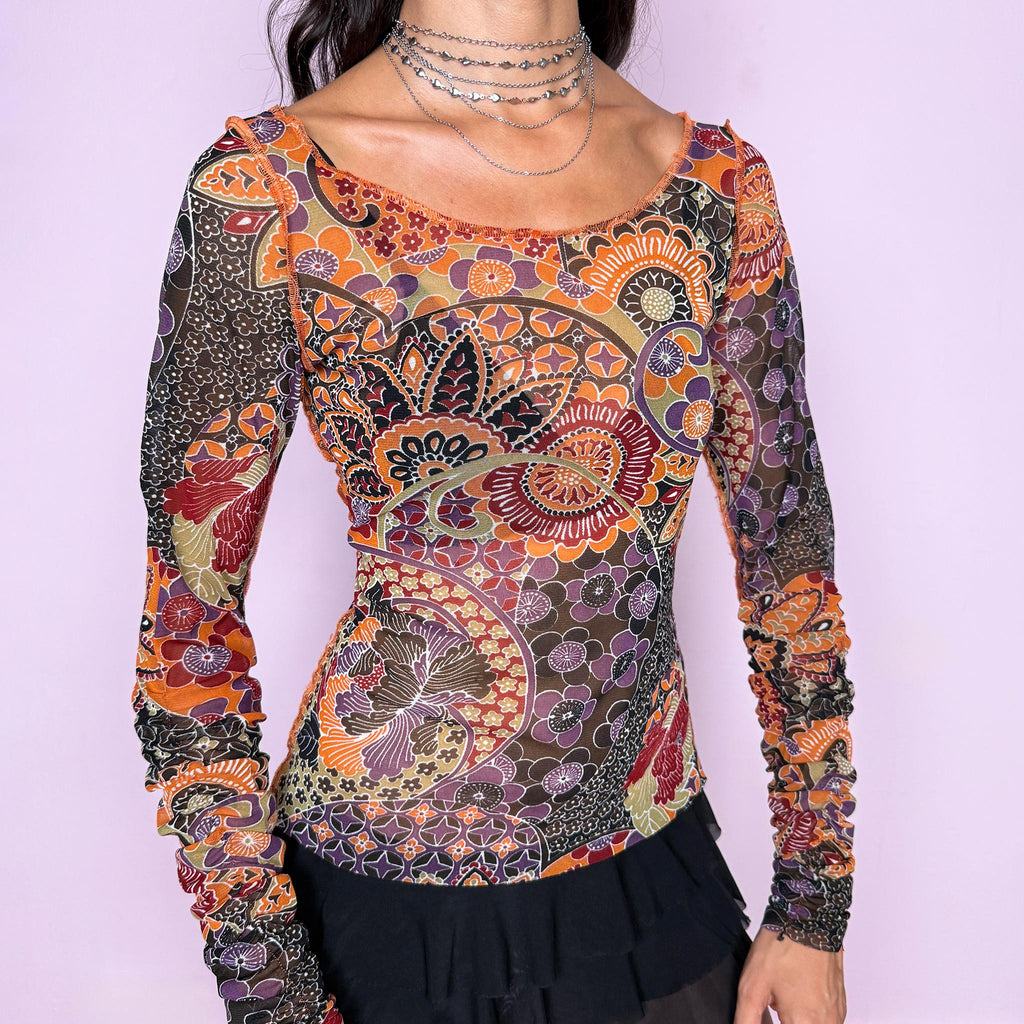 Vintage 2000s semi-sheer printed top featuring a fitted, stretchy silhouette with an intricate floral and paisley-inspired print in warm orange, burgundy, olive, brown, and muted purple tones. Designed with a wide scoop neckline and dramatic ruched long sleeves for a playful, maximalist art-to-wear aesthetic. Made in France by a French brand from 100% polyester. Excellent vintage condition.