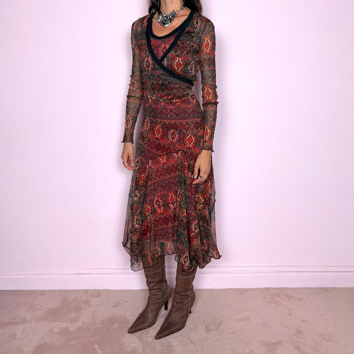 Vintage 2000s printed mesh two-piece dress set. The set includes a fitted sleeveless midi dress with a red lining and asymmetric layered hem, paired with a long-sleeve sheer mesh wrap top with tie fastening and contrasting black trim. Finished in an earthy red, burgundy, brown, and orange graphic print throughout. Perfect for layered bohemian styling. From a French brand, made in France from stretchy 100% polyester. Great vintage condition.