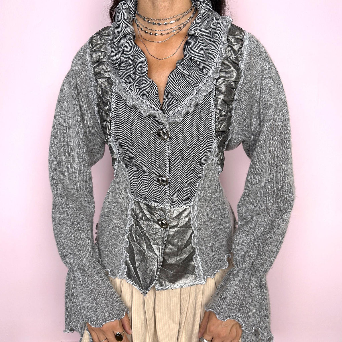 Vintage 2000s gray statement cardigan featuring a fitted, mixed-texture construction with contrasting herringbone panels and metallic crinkled faux leather inserts through the front. Designed with an oversized sculptural collar, decorative button closure, and flared cuffs for a deconstructed Y2K silhouette. From a French brand, crafted from a stretchy blend of 52% cotton, 25% acrylic, 16% polyester, and 7% mohair. Excellent vintage condition.