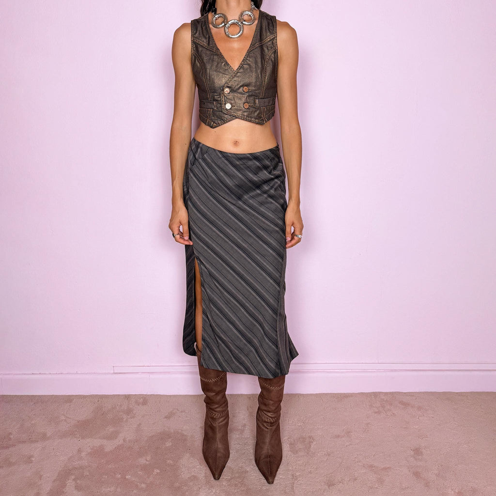 Vintage 2000s brownish-gray striped midi skirt by Kenzo Jungle, featuring diagonal stripe placement, a side slit, and a side zip closure. The muted brown-gray palette and refined tailoring give it a sophisticated, minimalist designer aesthetic. Can be worn mid-rise for size M. Crafted from a non-stretch blend of 58% viscose, 30% wool, 9% mohair, and 3% elastane, with a 100% polyester lining. Excellent vintage condition.