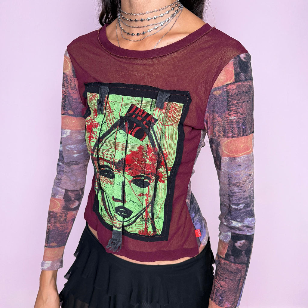 Vintage 2000s deconstructed graphic mesh top featuring a fitted burgundy body with contrasting printed long sleeves and a bold mixed-media face graphic appliqué at the front, finished with raw-edge fabric tabs and layered textile detailing. The combination of mesh, painterly print, and exposed appliqué construction gives it an art-to-wear, avant-garde aesthetic. From a French brand, made in France from stretchy 100% polyamide. Great vintage condition.