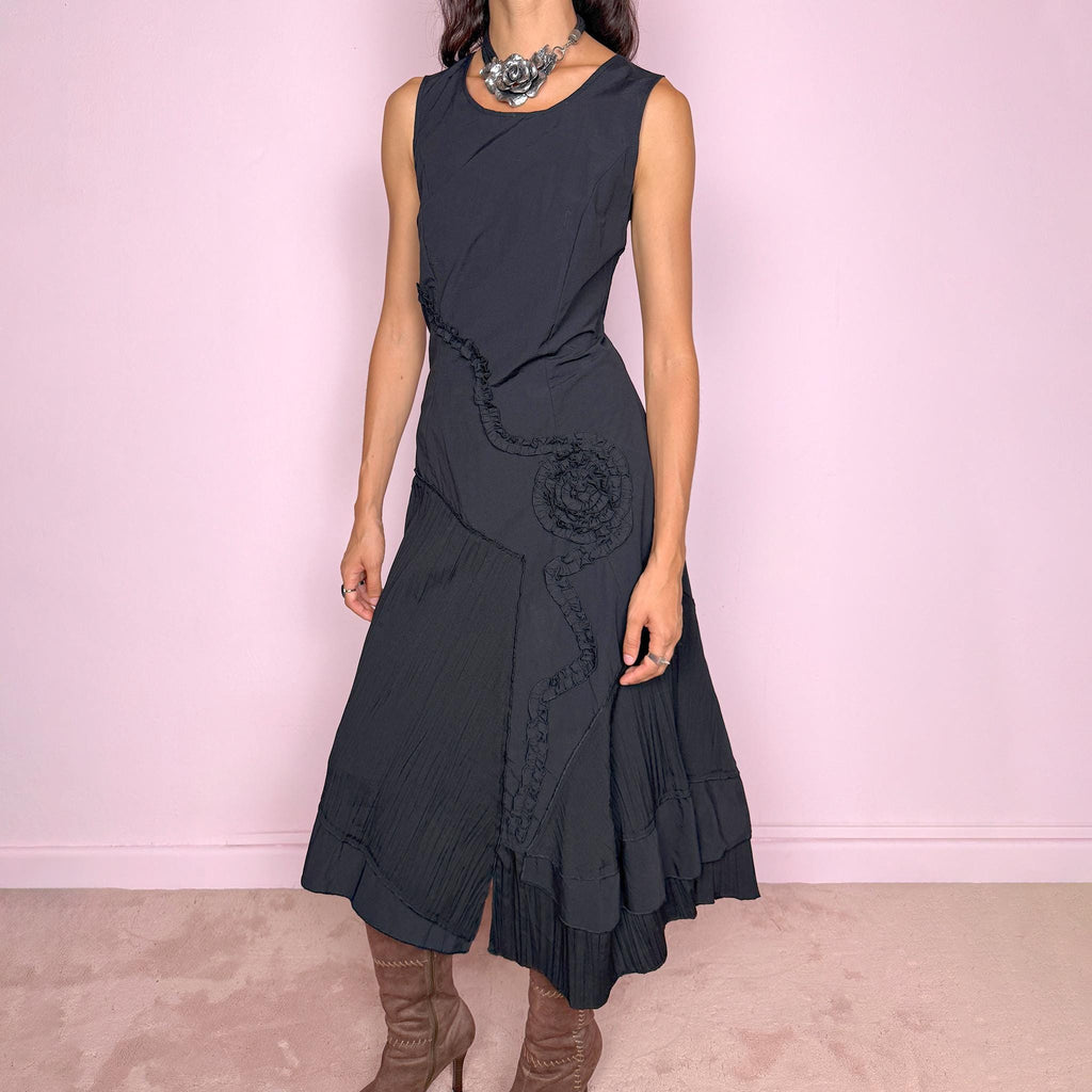 Vintage 2000s black asymmetric midi dress featuring a sleeveless silhouette with sculptural panel construction, mixed tonal textures, and ruffled trim creating an organic, deconstructed effect across the body. Finished with an irregular asymmetric hem and back zip closure. No stretch. For dark avant-garde looks. Made in France by a French brand. Main fabric: 61% viscose and 39% polyester. Other fabric: 54% cotton and 46% polyamide. Excellent vintage condition.