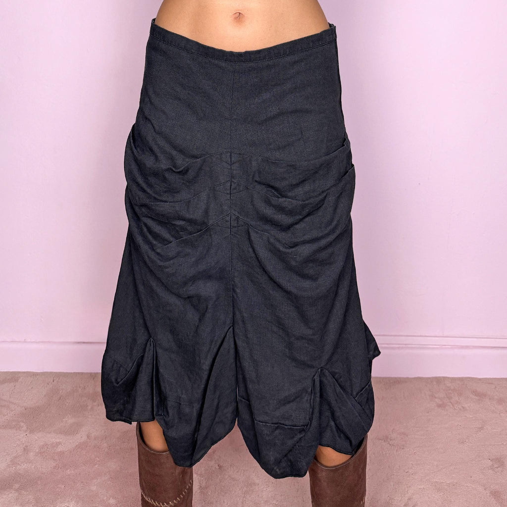 Vintage 2000s black linen midi skirt crafted from 100% linen. Featuring sculptural gathered draping through the front, curved panel construction and an irregular flared hem. The slightly faded black tone and natural linen texture give it a rustic, deconstructed avant-garde aesthetic. Non-stretch with 100% polyester lining. Can be worn mid-rise for size S or lower on the waist for size XS. From a Dutch brand. Excellent vintage condition.