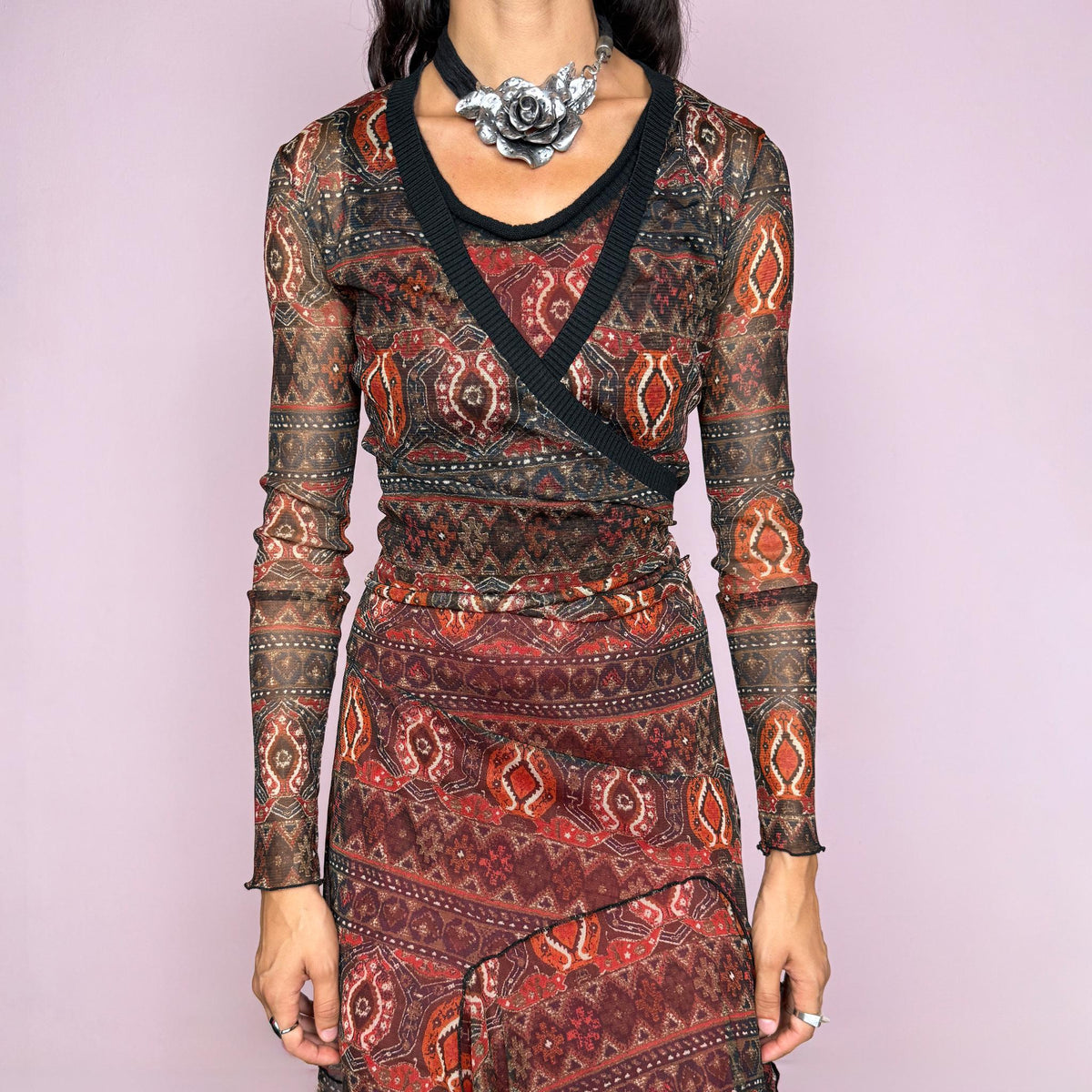 Vintage 2000s printed mesh two-piece dress set. The set includes a fitted sleeveless midi dress with a red lining and asymmetric layered hem, paired with a long-sleeve sheer mesh wrap top with tie fastening and contrasting black trim. Finished in an earthy red, burgundy, brown, and orange graphic print throughout. Perfect for layered bohemian styling. From a French brand, made in France from stretchy 100% polyester. Great vintage condition.
