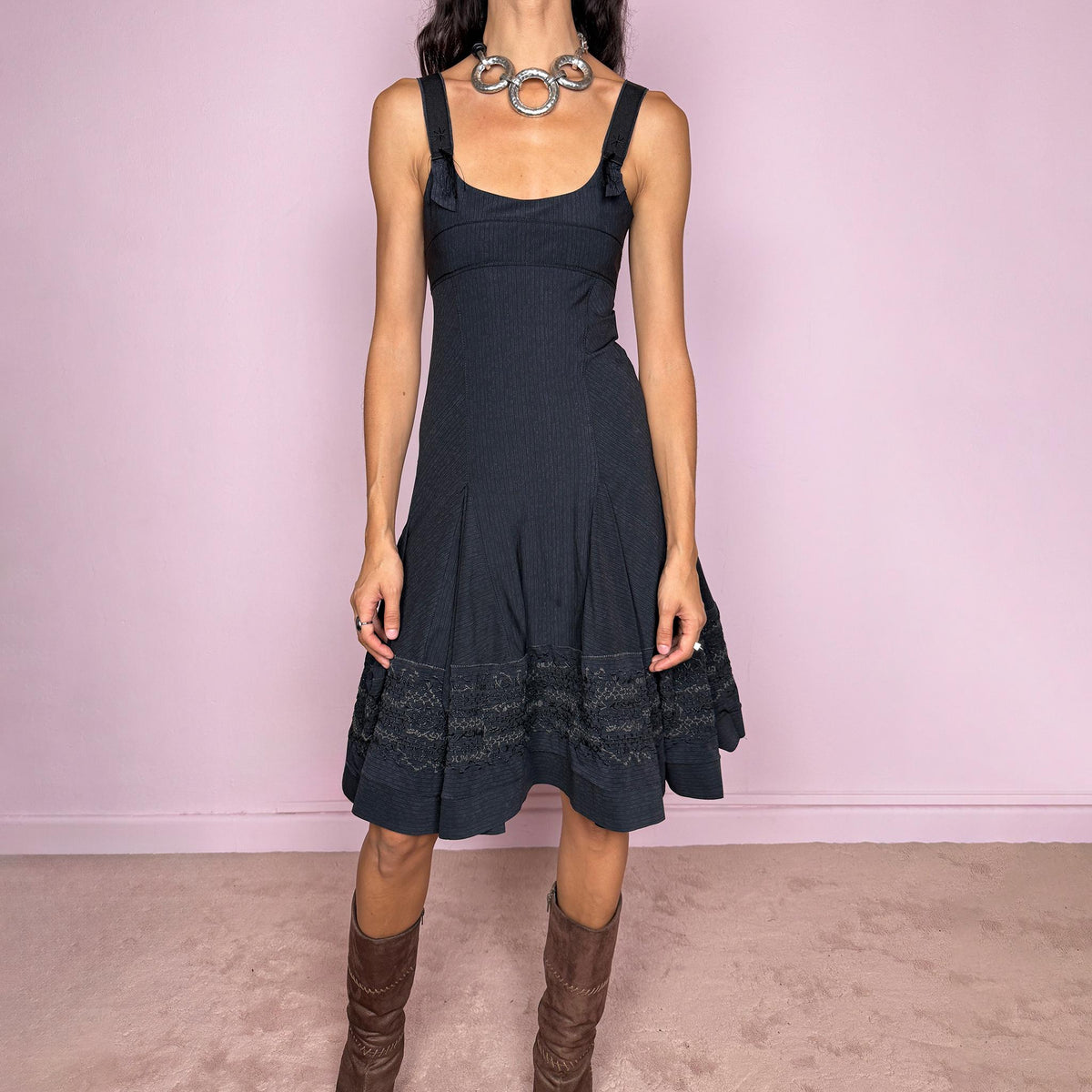 Vintage 2000s black midi dress by French label Marithé + François Girbaud, featuring a fitted sleeveless bodice with a scoop neckline and curved seam construction through the torso. The fabric has a subtle micro-pinstripe texture, while the silhouette flares from the hips into a structured A-line skirt with embroidered details. Made from a stretchy blend of 72% polyamide and 28% elastane. Excellent vintage condition.