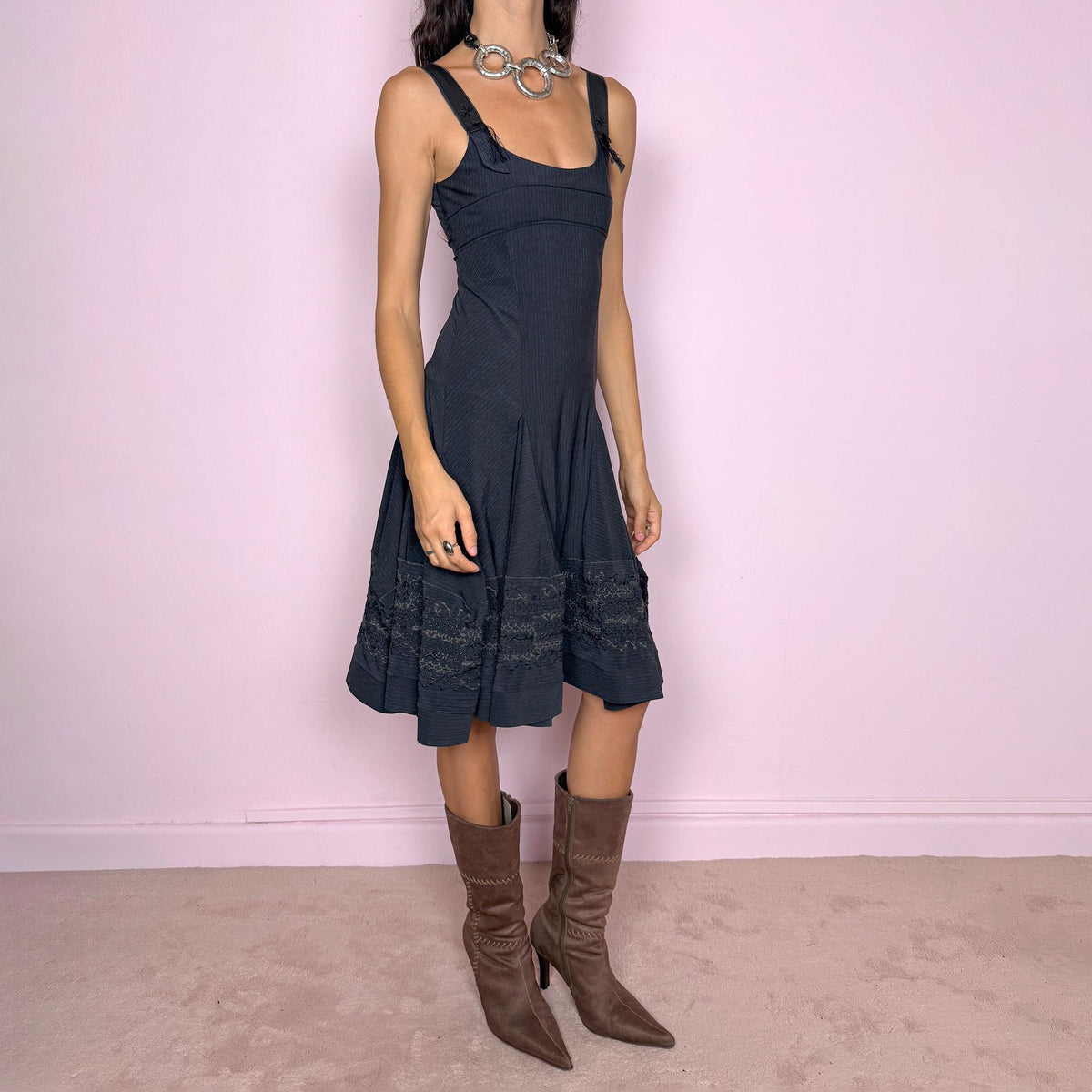 Vintage 2000s black midi dress by French label Marithé + François Girbaud, featuring a fitted sleeveless bodice with a scoop neckline and curved seam construction through the torso. The fabric has a subtle micro-pinstripe texture, while the silhouette flares from the hips into a structured A-line skirt with embroidered details. Made from a stretchy blend of 72% polyamide and 28% elastane. Excellent vintage condition.