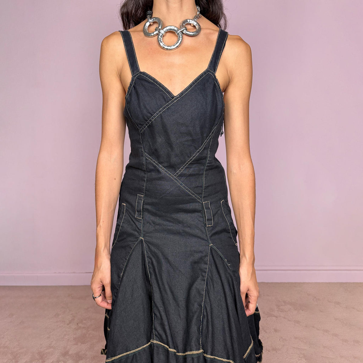 Vintage 2000s black linen midi dress by French designer label Marithé + François Girbaud, made from 100% non-stretch linen. Features adjustable shoulder straps with snap-button fastenings, a fitted paneled bodice, contrast topstitching, a side zip closure, and pockets. The skirt flares into a sculptural asymmetric hem with gathered sections and ruffled edges. Excellent vintage condition.