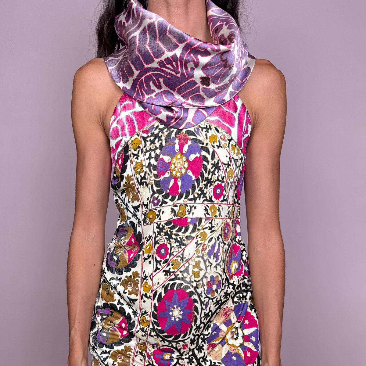 Vintage 2000s sleeveless mini dress from Class Roberto Cavalli, the diffusion line of Italian designer Roberto Cavalli. Features a straight silhouette, a draped cowl neckline and a vivid multicolor ornamental print over a cream base, with pink, purple, black and gold tones. Finished with a side zip closure and slight stretch. The composition label is faded and no longer legible, so the exact fabric content is unknown. Excellent vintage condition.