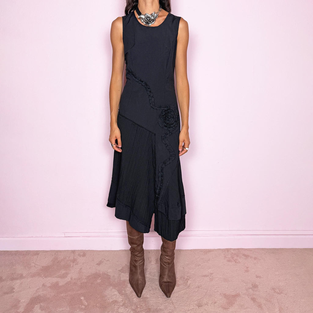 Vintage 2000s black asymmetric midi dress featuring a sleeveless silhouette with sculptural panel construction, mixed tonal textures, and ruffled trim creating an organic, deconstructed effect across the body. Finished with an irregular asymmetric hem and back zip closure. No stretch. For dark avant-garde looks. Made in France by a French brand. Main fabric: 61% viscose and 39% polyester. Other fabric: 54% cotton and 46% polyamide. Excellent vintage condition.