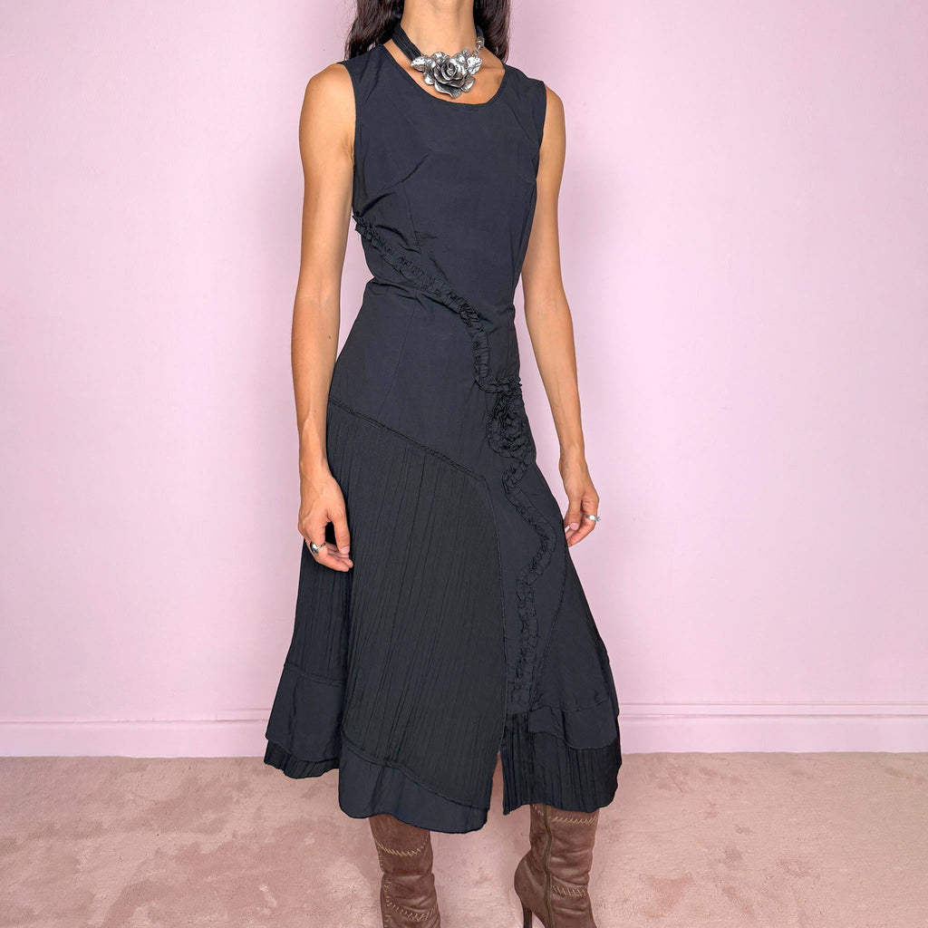 Vintage 2000s black asymmetric midi dress featuring a sleeveless silhouette with sculptural panel construction, mixed tonal textures, and ruffled trim creating an organic, deconstructed effect across the body. Finished with an irregular asymmetric hem and back zip closure. No stretch. For dark avant-garde looks. Made in France by a French brand. Main fabric: 61% viscose and 39% polyester. Other fabric: 54% cotton and 46% polyamide. Excellent vintage condition.