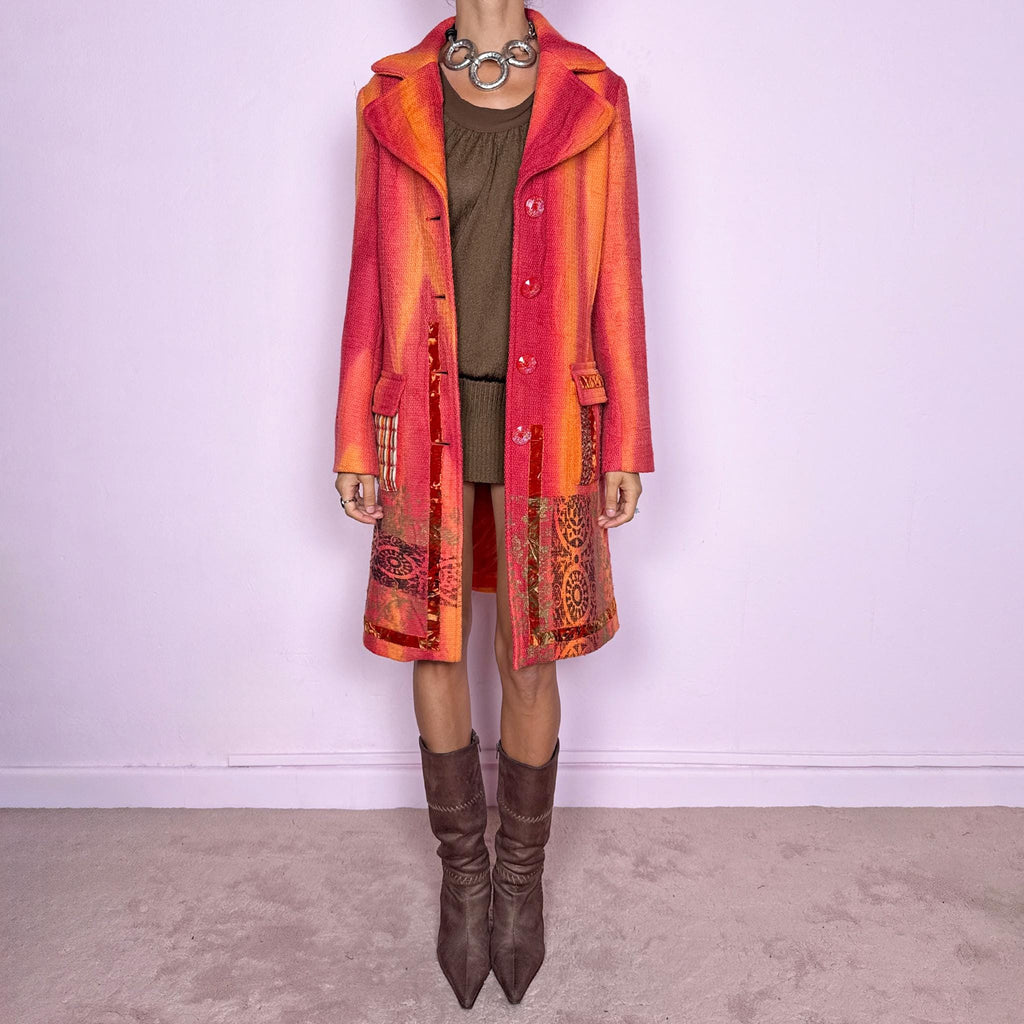 Vintage 2000s statement coat by Italian label Save the Queen, made in Italy from 100% virgin wool. Features a fitted longline silhouette in vivid coral, orange and red tones, with oversized notched lapels, decorative front buttons and contrasting mixed-media patch pockets. The lower section is finished with richly patterned jacquard-style panels, metallic accents and ornamental motifs, creating a highly detailed maximalist construction. Excellent vintage condition.
