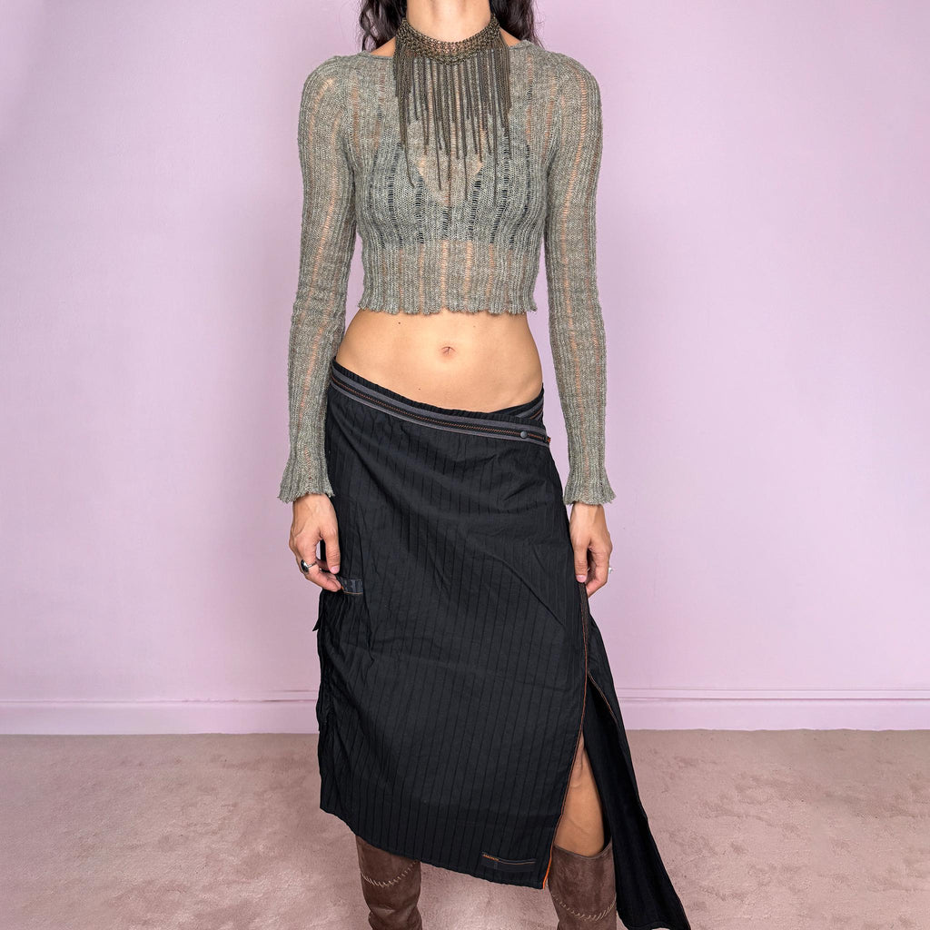 Vintage 2000s black midi skirt by French label Cop Copine, made from 100% cotton with no stretch. Features an asymmetric wrap-style construction, subtle vertical stripe texture, snap-button fastening at the waist, and a dramatic side slit with contrast topstitching. Finished with layered panel detailing for a deconstructed, utilitarian, dark avant-garde look. Can be worn mid-rise for size M or lower on the waist for size S. Excellent vintage condition.