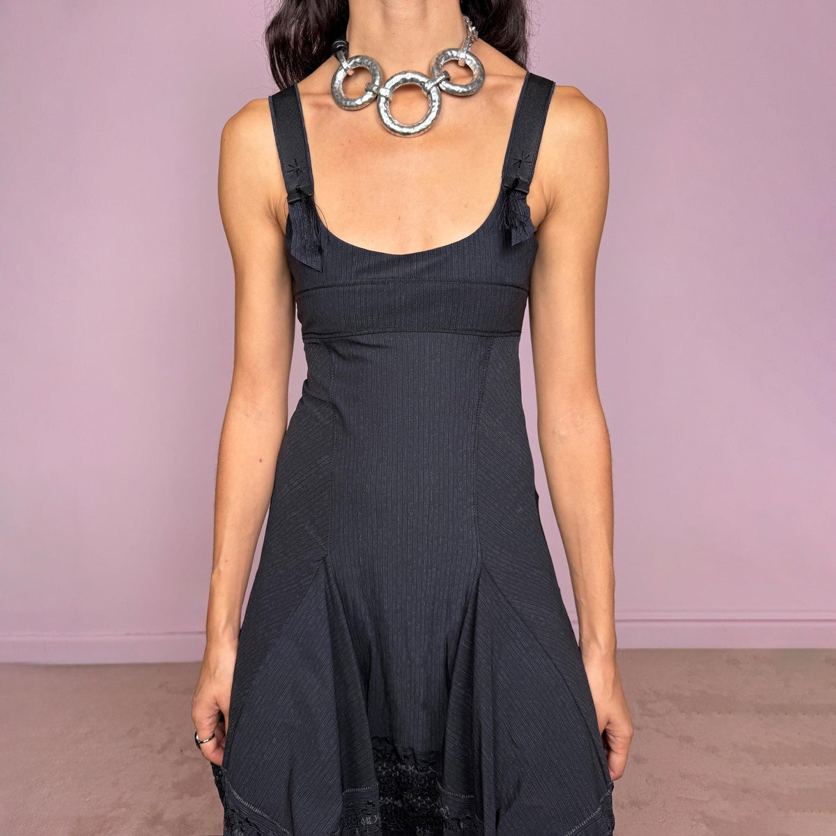 Vintage 2000s black midi dress by French label Marithé + François Girbaud, featuring a fitted sleeveless bodice with a scoop neckline and curved seam construction through the torso. The fabric has a subtle micro-pinstripe texture, while the silhouette flares from the hips into a structured A-line skirt with embroidered details. Made from a stretchy blend of 72% polyamide and 28% elastane. Excellent vintage condition.