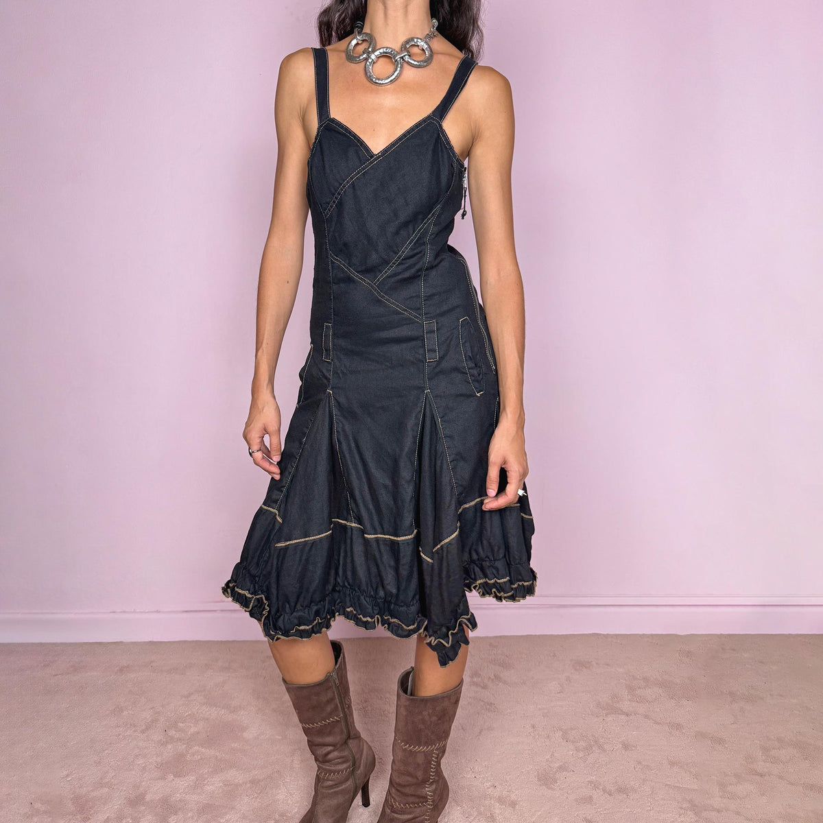 Vintage 2000s black linen midi dress by French designer label Marithé + François Girbaud, made from 100% non-stretch linen. Features adjustable shoulder straps with snap-button fastenings, a fitted paneled bodice, contrast topstitching, a side zip closure, and pockets. The skirt flares into a sculptural asymmetric hem with gathered sections and ruffled edges. Excellent vintage condition.