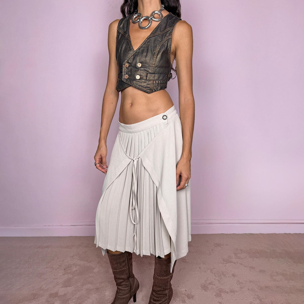 Vintage 90s pale beige midi skirt featuring a pleated base with a layered wrap overlay that can be tied at the center or back, and a side button closure, creating a deconstructed architectural silhouette. Can be worn mid-rise for size M or lower on the waist for size S. Made in France by a French brand from 100% non-stretch polyester. Excellent vintage condition.