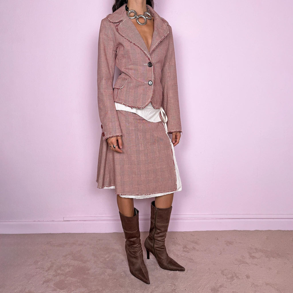 Vintage 2000s burgundy-red and cream two-piece skirt suit. The set includes a fitted blazer with a glen plaid / Prince of Wales check pattern, raw-edge trim, notched lapels, and a two-button front closure. Paired with a matching wrap-style midi skirt featuring layered cream lining, a side button closure, and an adjustable tie. The contrasting construction and unfinished edges create a relaxed, deconstructed feel while maintaining a tailored silhouette.