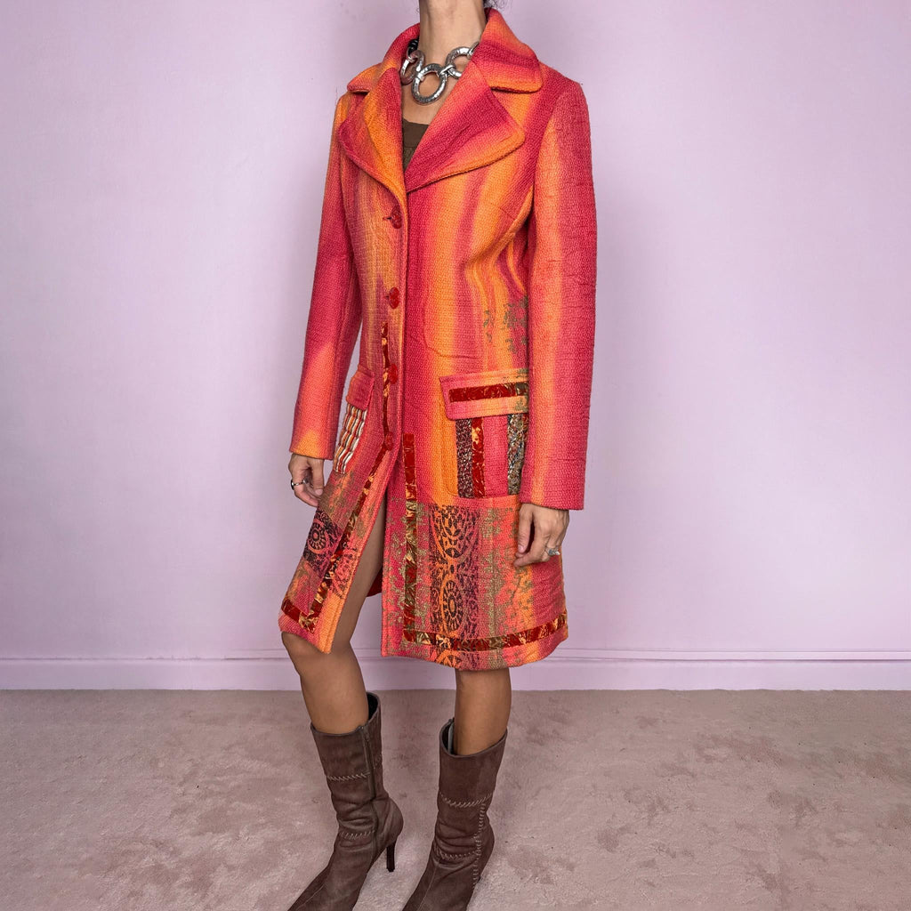 Vintage 2000s statement coat by Italian label Save the Queen, made in Italy from 100% virgin wool. Features a fitted longline silhouette in vivid coral, orange and red tones, with oversized notched lapels, decorative front buttons and contrasting mixed-media patch pockets. The lower section is finished with richly patterned jacquard-style panels, metallic accents and ornamental motifs, creating a highly detailed maximalist construction. Excellent vintage condition.