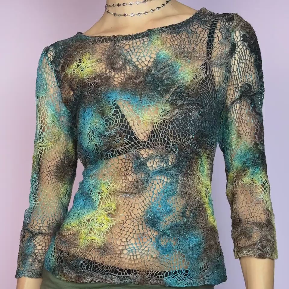 The Y2K Open Knit Mesh Top is a unique vintage 2000s piece featuring an intricate open-knit design, this semi-sheer top boasts a dreamy tie-dye-inspired blend of earthy hues in brown, blue and green. With its 3/4 sleeves and lightweight, breathable fabric, this top is ideal for an edgy, boho-inspired summer look.